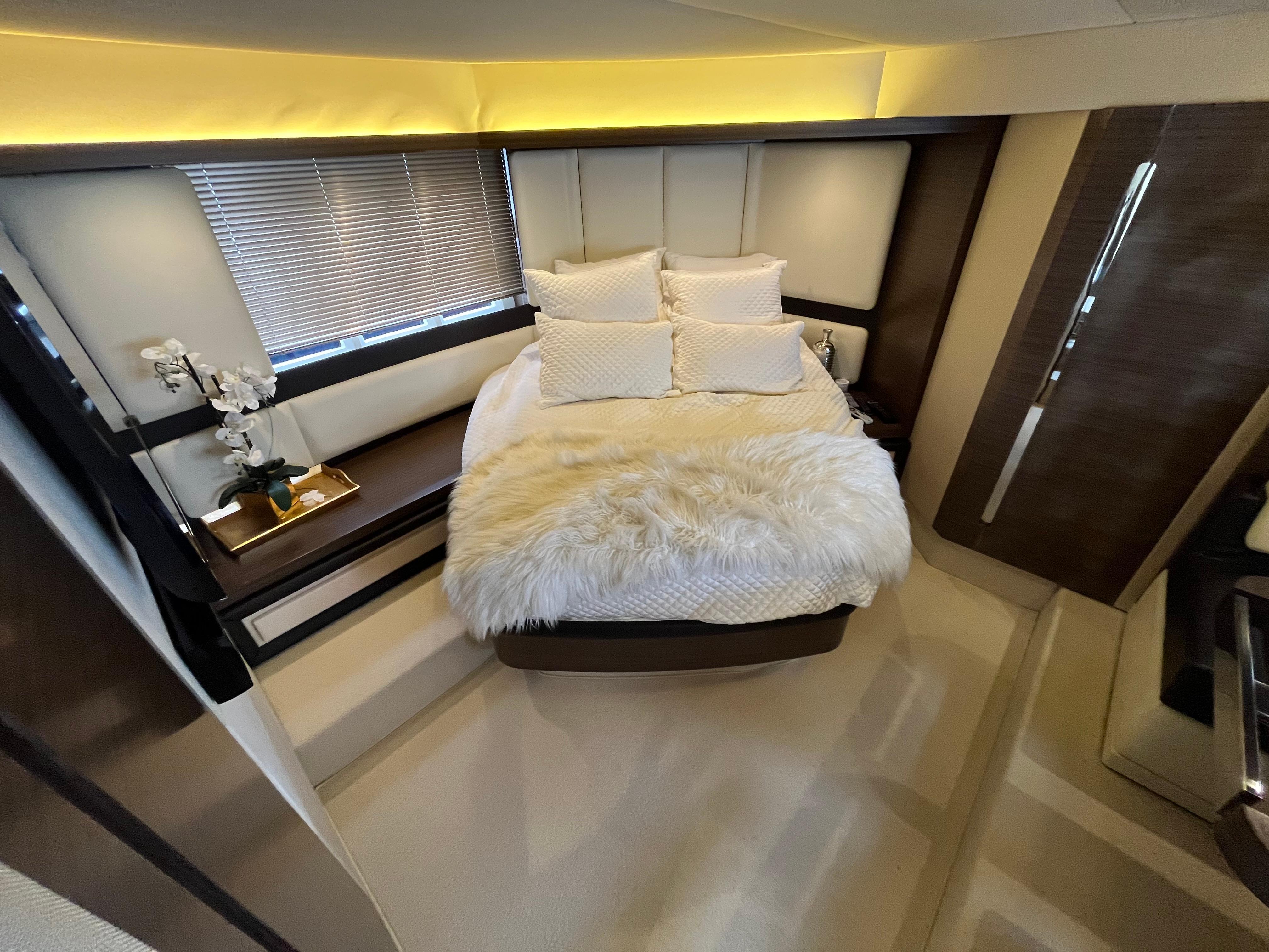 Luxurious bedroom interior of 2014 Azimut 55S yacht with plush bedding and elegant decor.