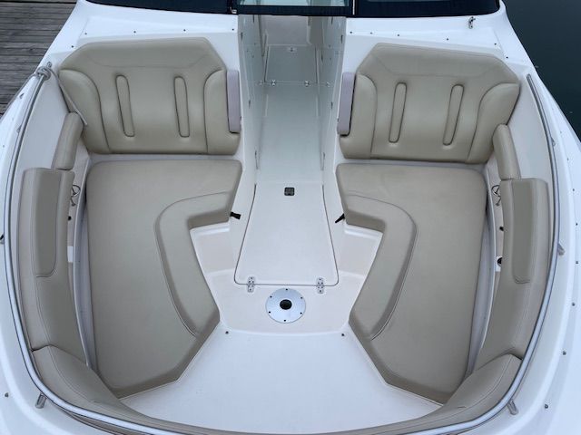 The image shows the bow area of a Pursuit DC 325 Dual Console boat with beige upholstery.