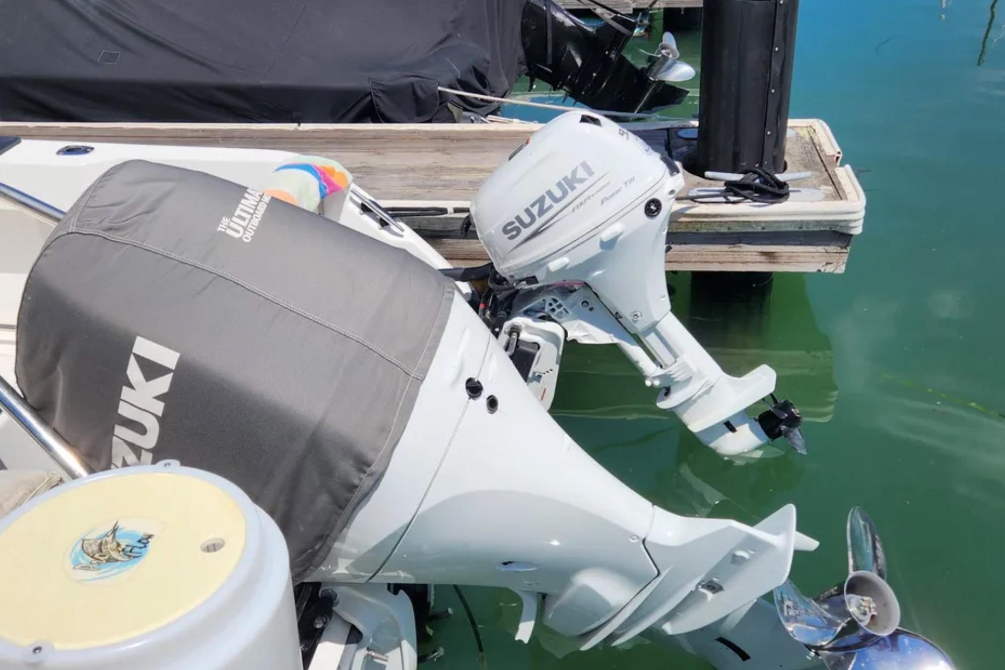 Outboard motors on a 2000 Boston Whaler 21 Conquest docked in clear water.