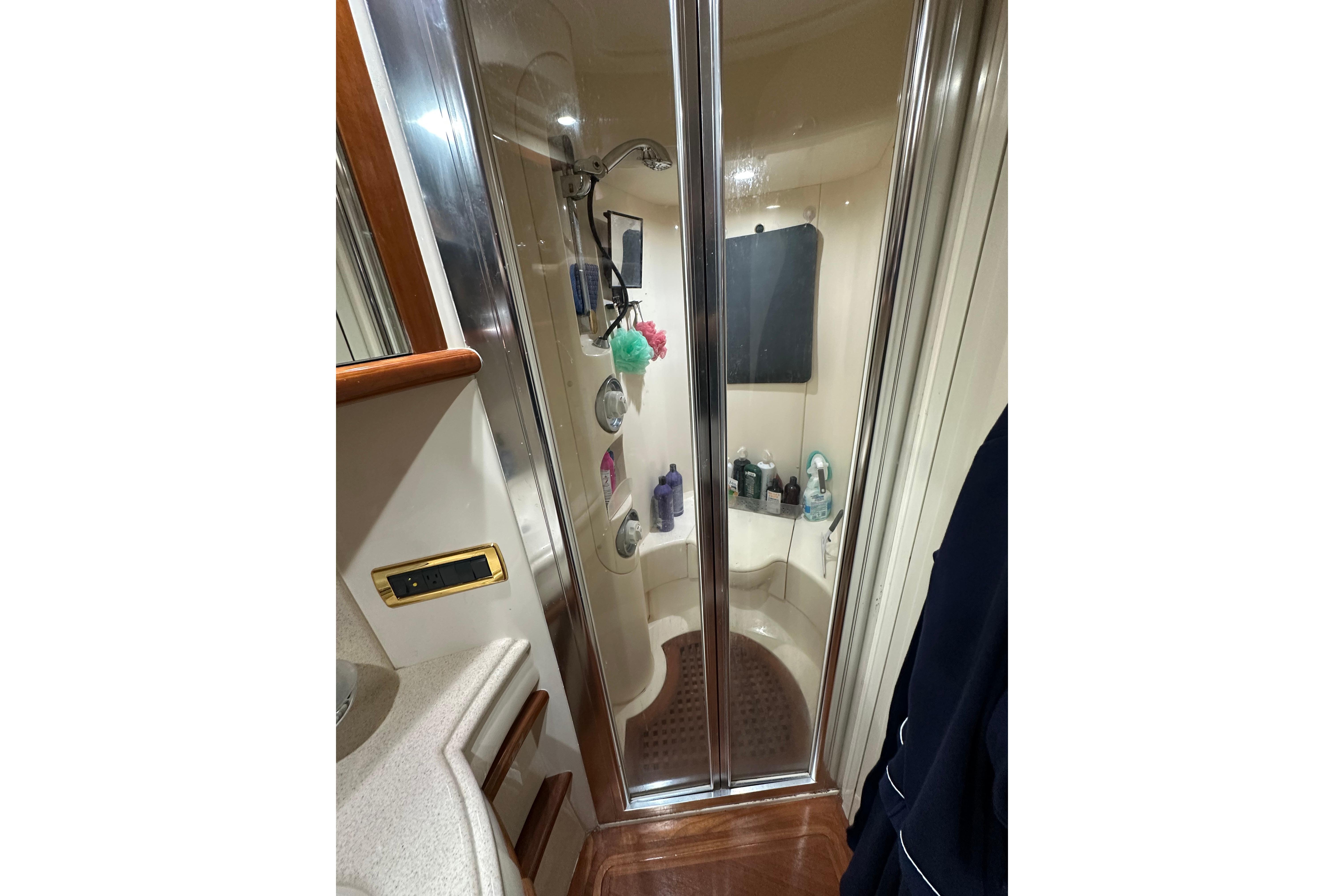 Luxurious shower area in 2004 Azimut 55E yacht, featuring glass doors and modern fixtures.