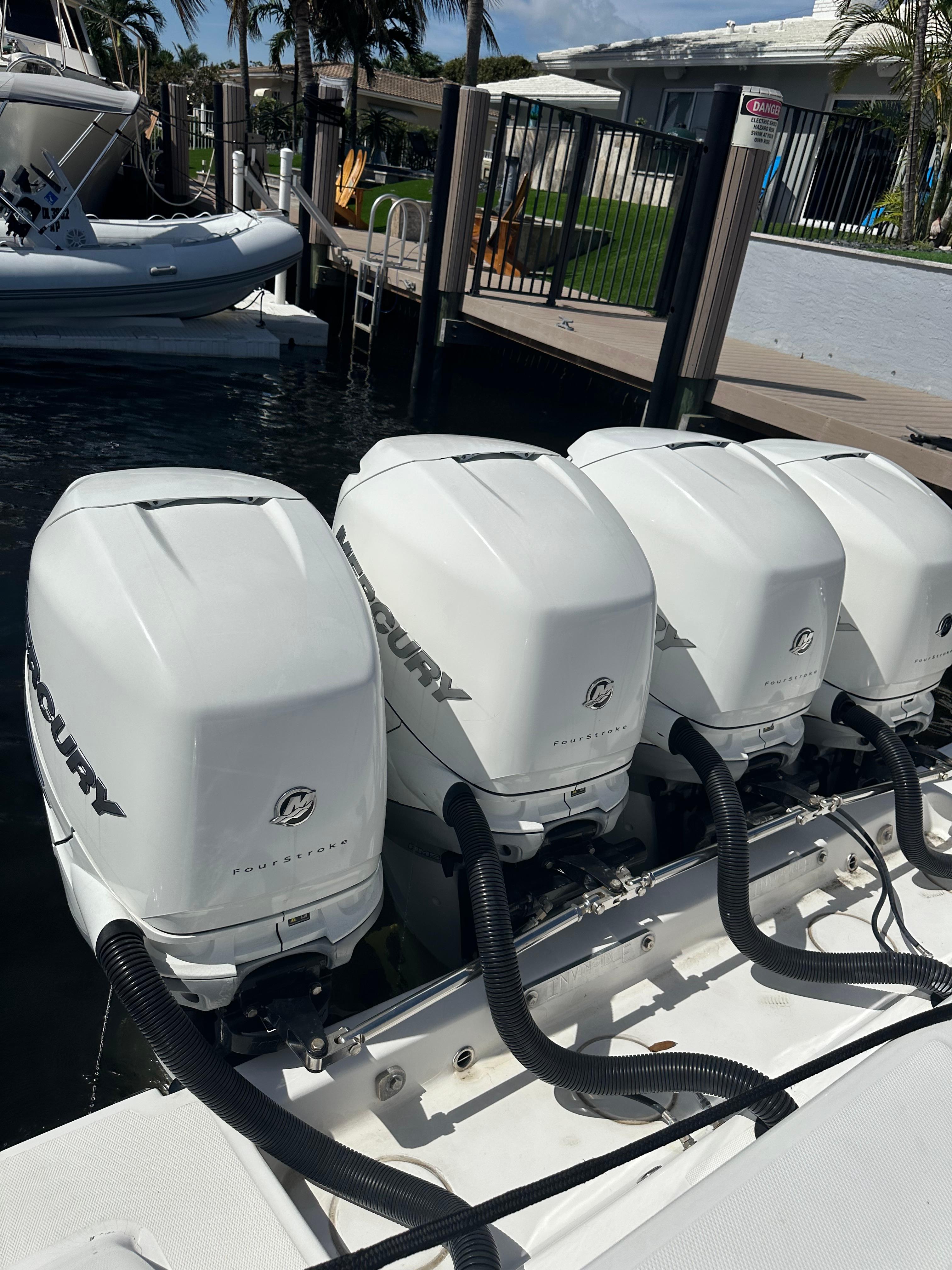 2016 Invincible Open Fisherman boat with four Mercury outboard engines docked.