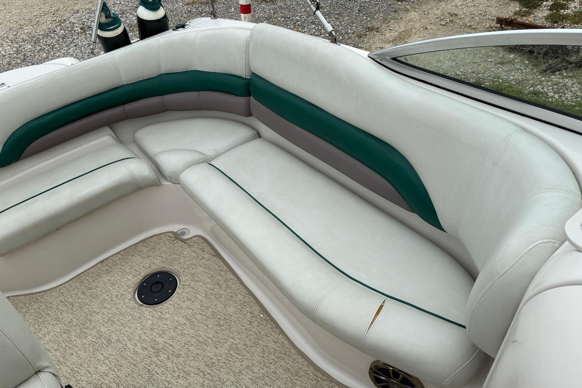 2003 Hurricane 234 SD boat interior with white and green seating, beige carpet.