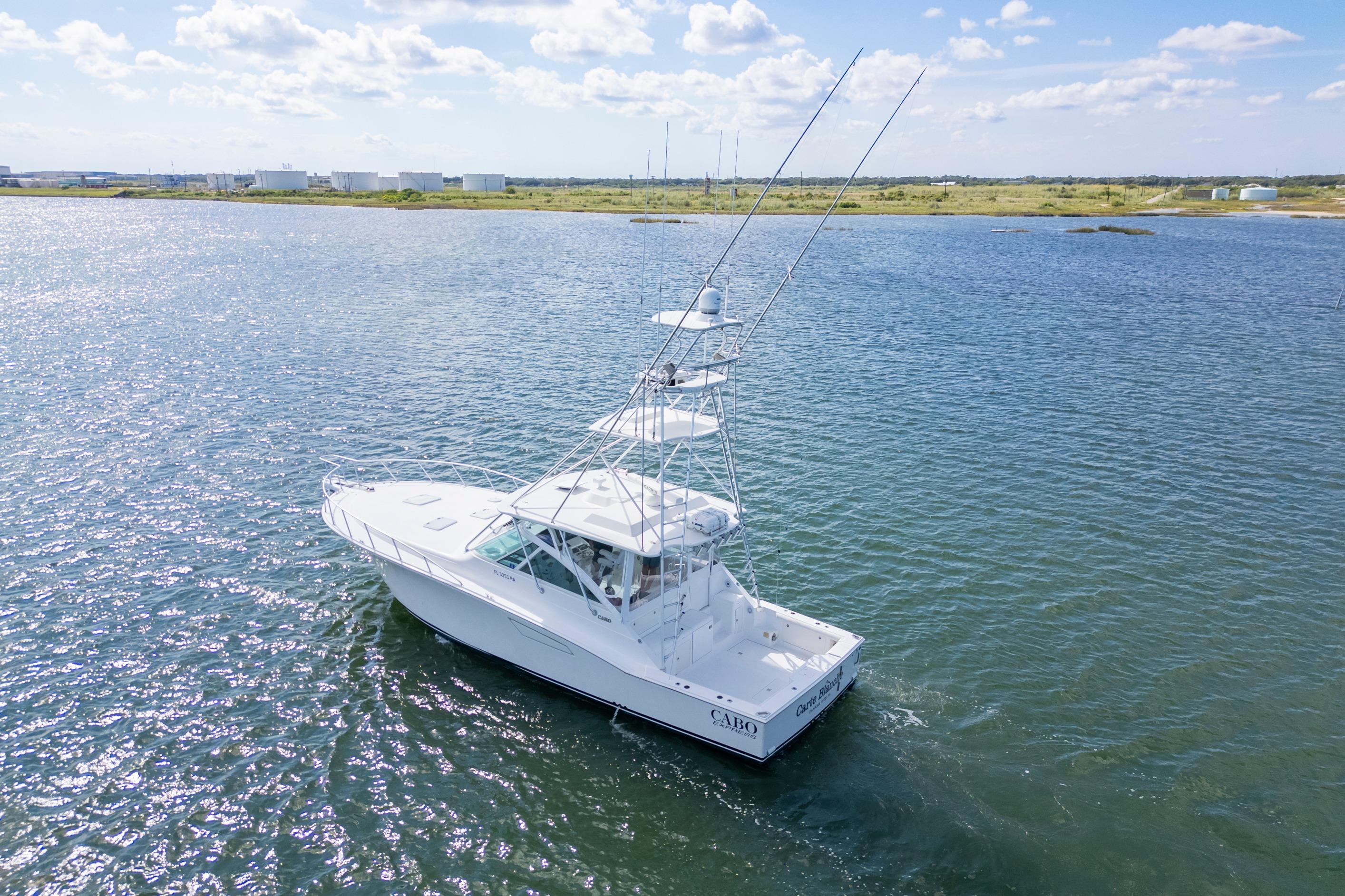 2010 Cabo 45 Express boat cruising on a sunny day in open water.