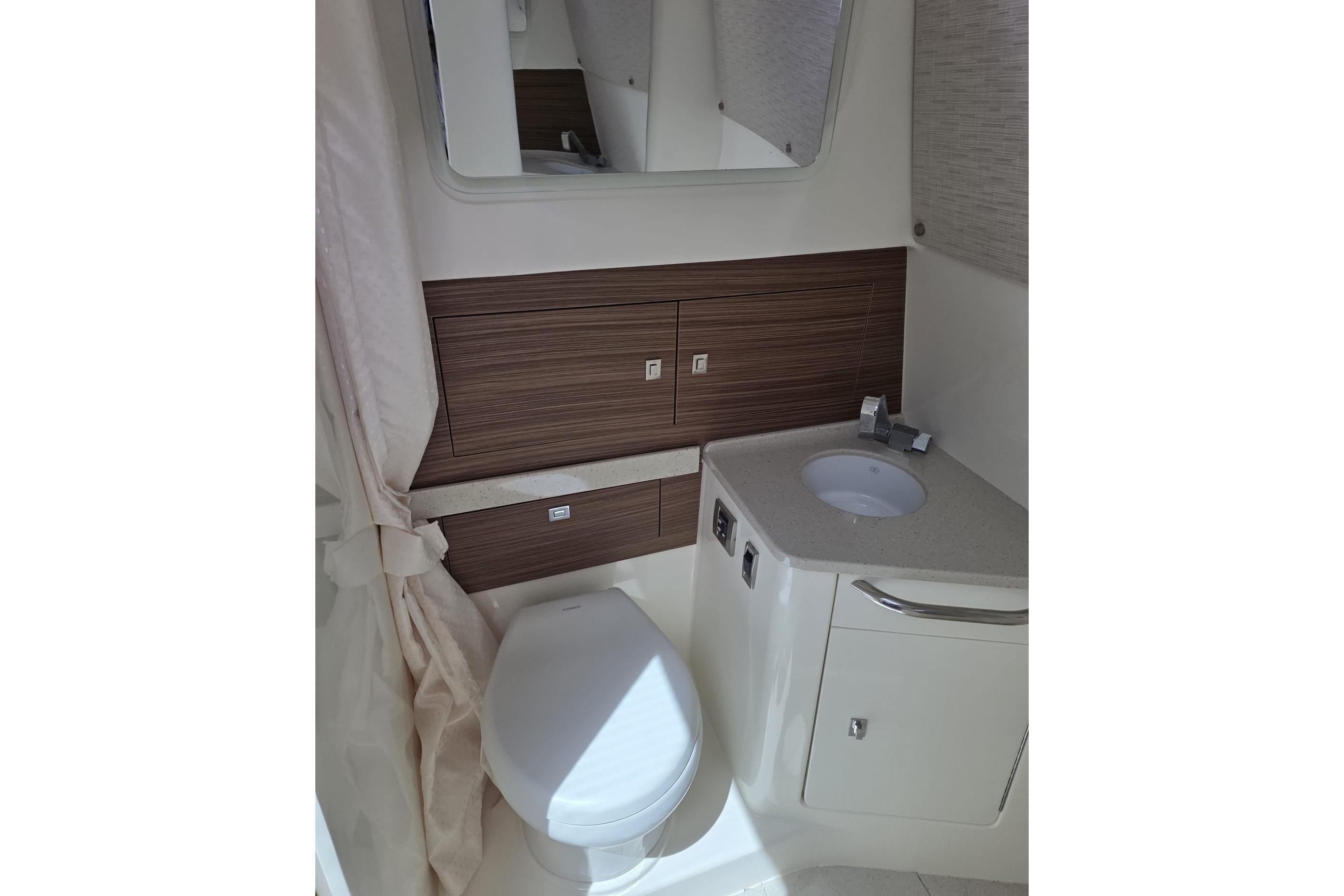 2020 Boston Whaler 420 Outrage bathroom with modern fixtures and wood accents.