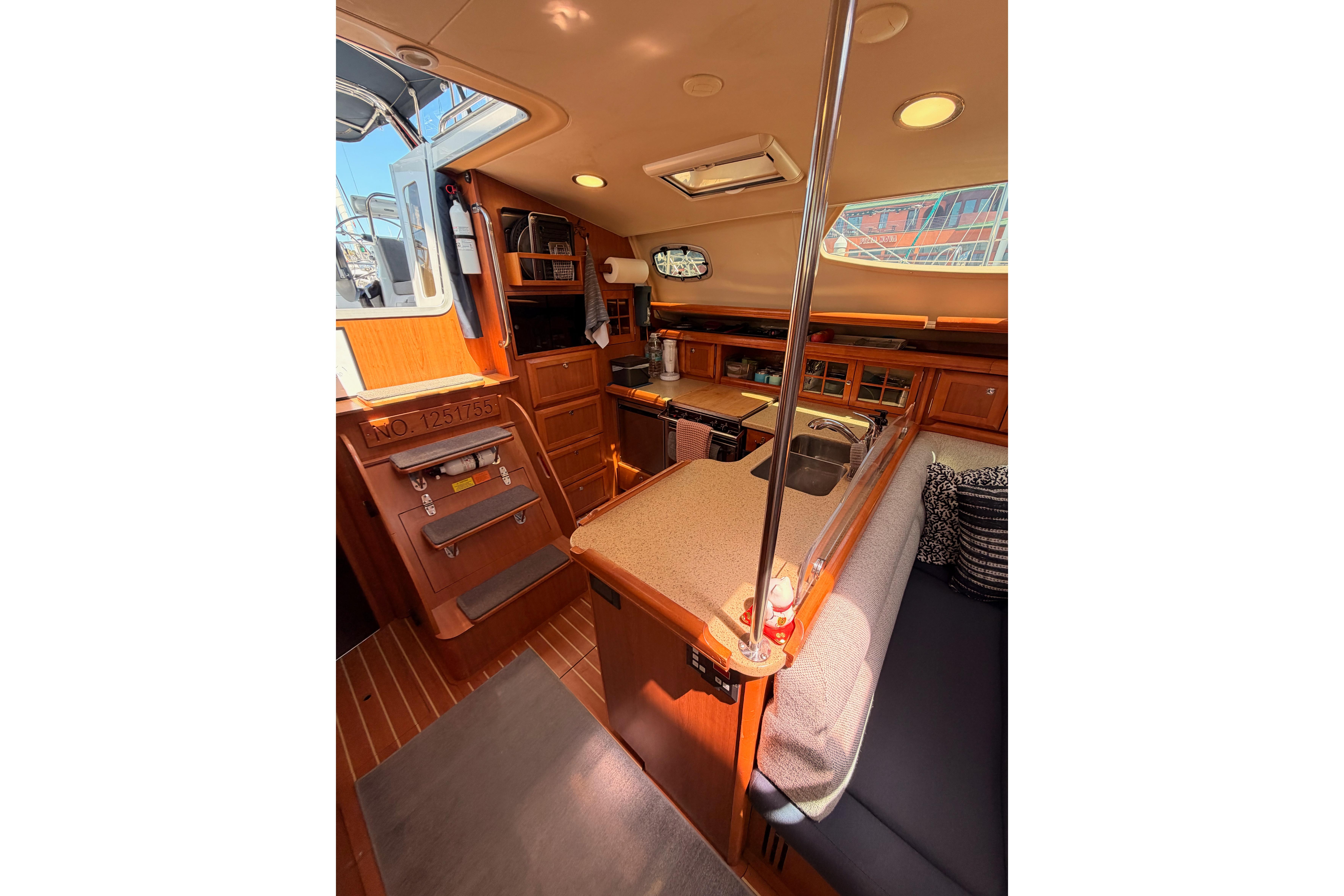 Interior of 2008 Hunter 45 Deck Salon yacht, featuring a cozy kitchen and seating area.