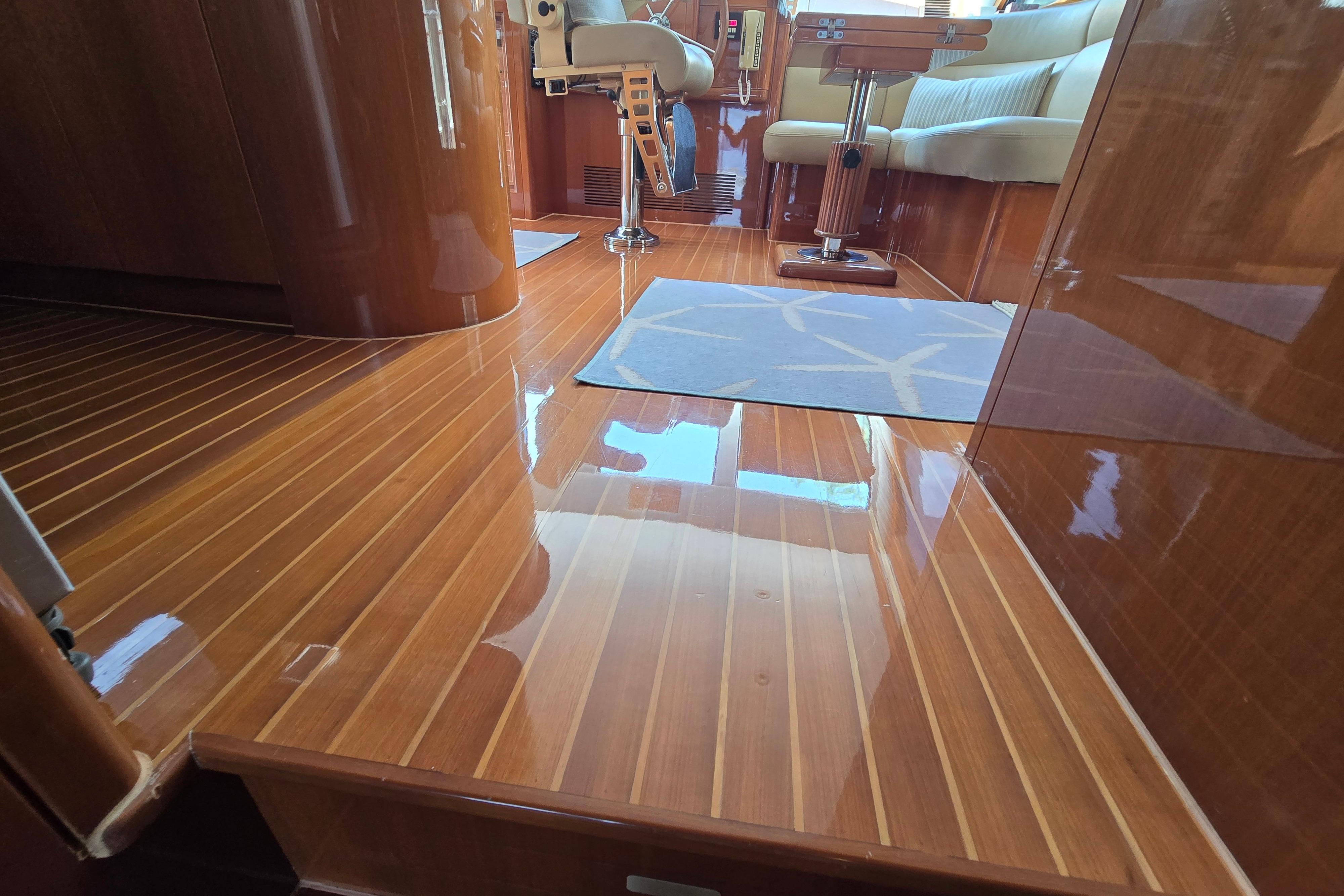 Luxurious wooden interior of a 2004 Grand Harbour 58 yacht, featuring polished floors and elegant seating.