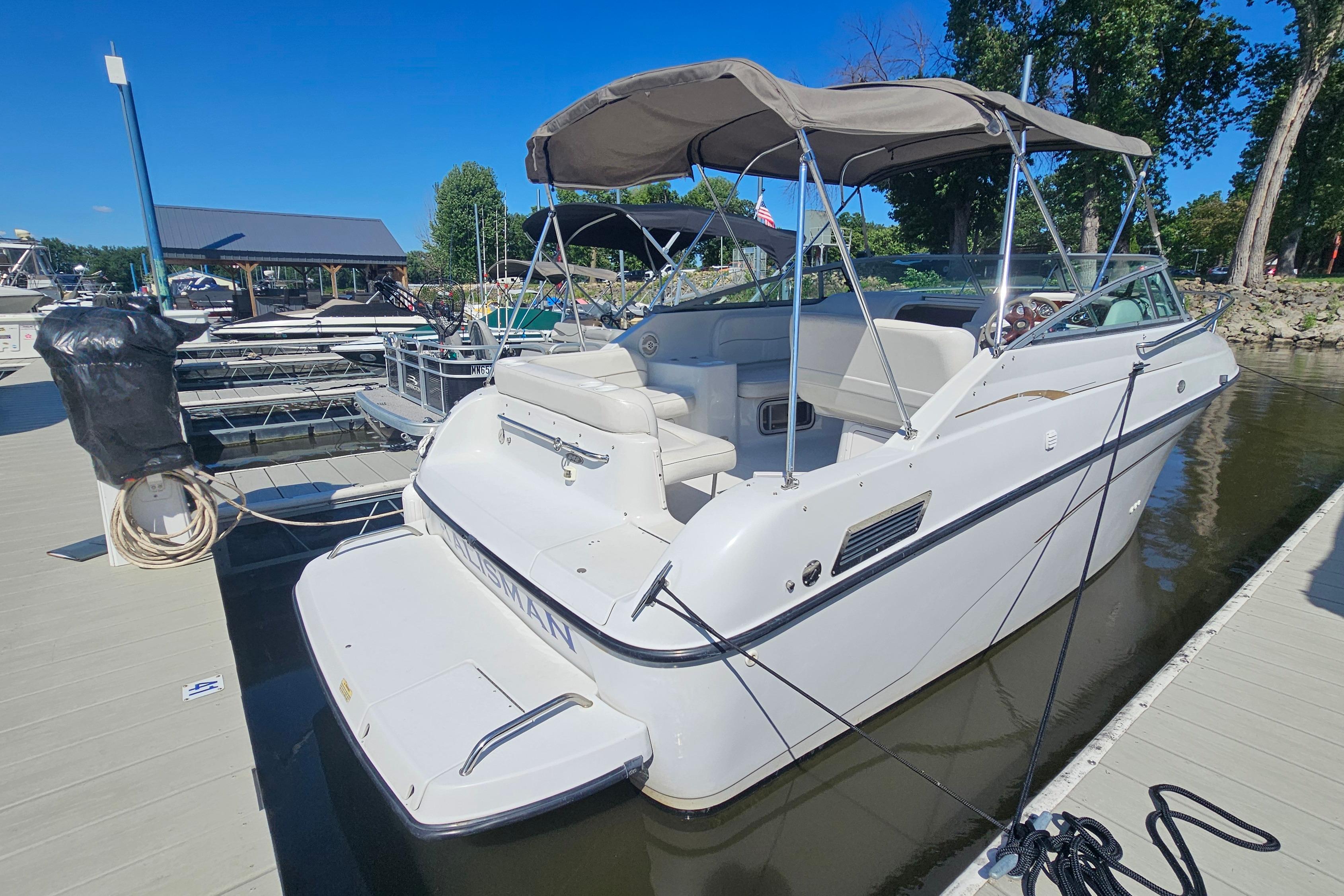 2000 Crownline 242 CR boat docked at marina under clear blue sky.