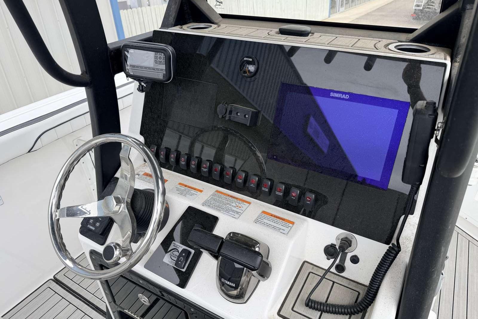 2023 Yamaha Boats 255 FSH Sport E dashboard with steering wheel and navigation controls.