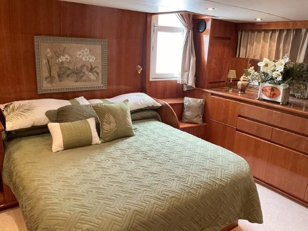 Luxurious bedroom in 2000 Novatec Islander 55 yacht with green bedding and wooden decor.
