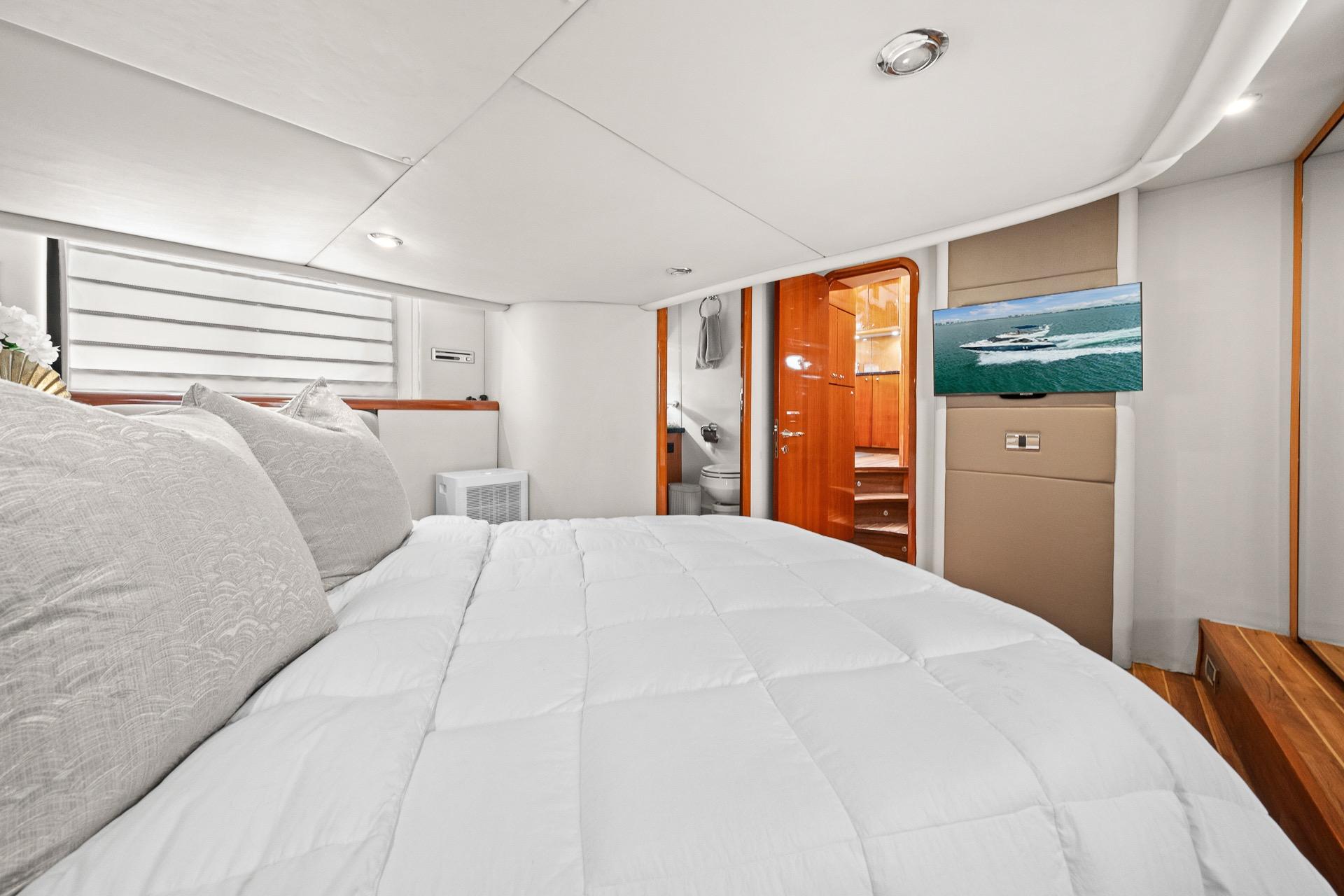 Luxurious bedroom interior of 2006 Sunseeker Manhattan 50 yacht with modern amenities.