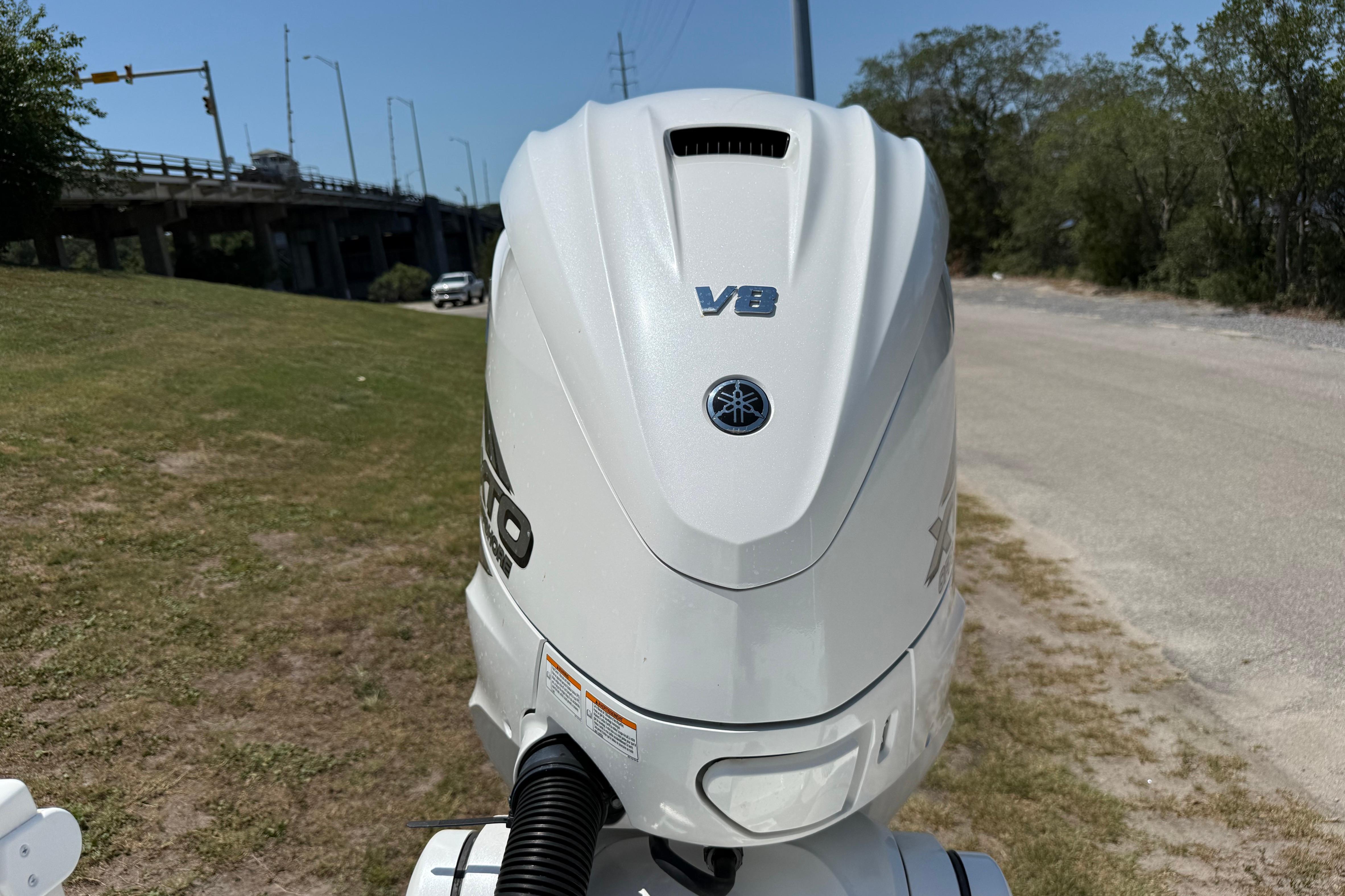 2023 Regulator 26XO boat with Yamaha V8 engine, parked near a road.