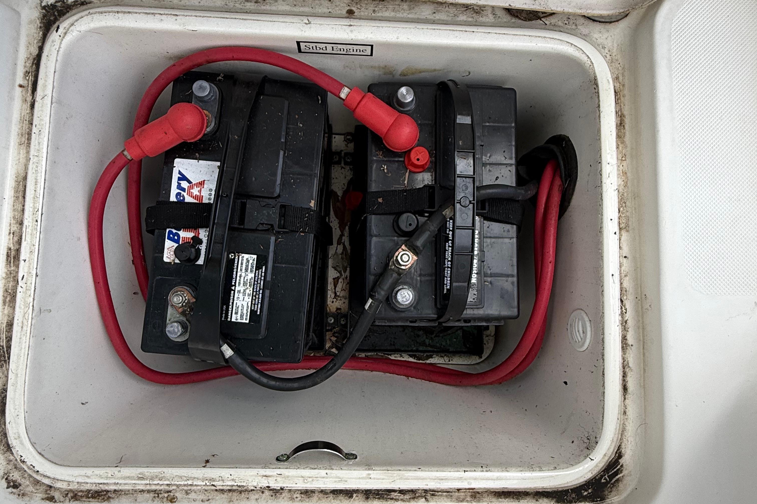 Two marine batteries with red cables in a 2008 Century 2901 Center Console boat.