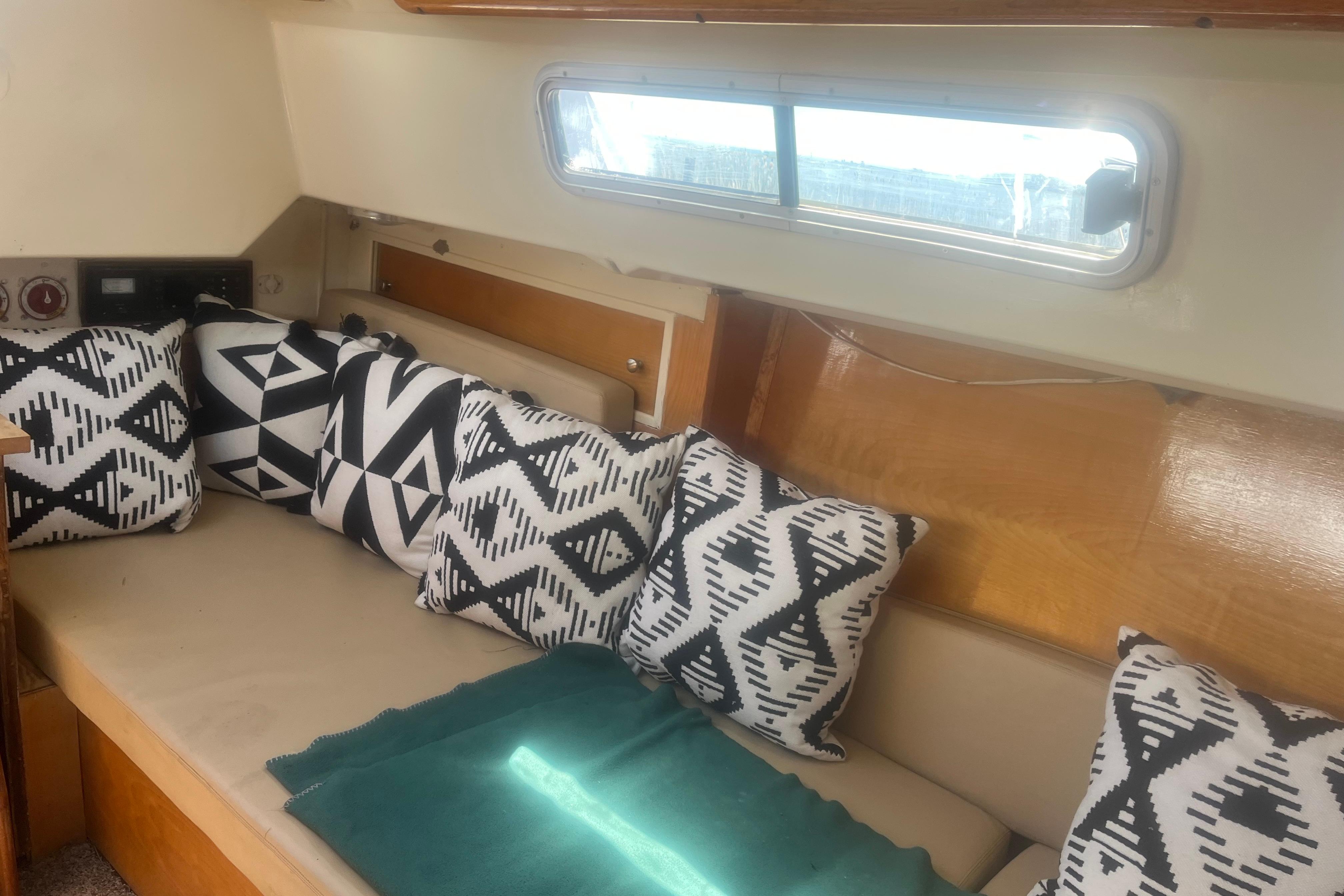 Interior of a 1972 C&C 30 sailboat with patterned cushions and a window.