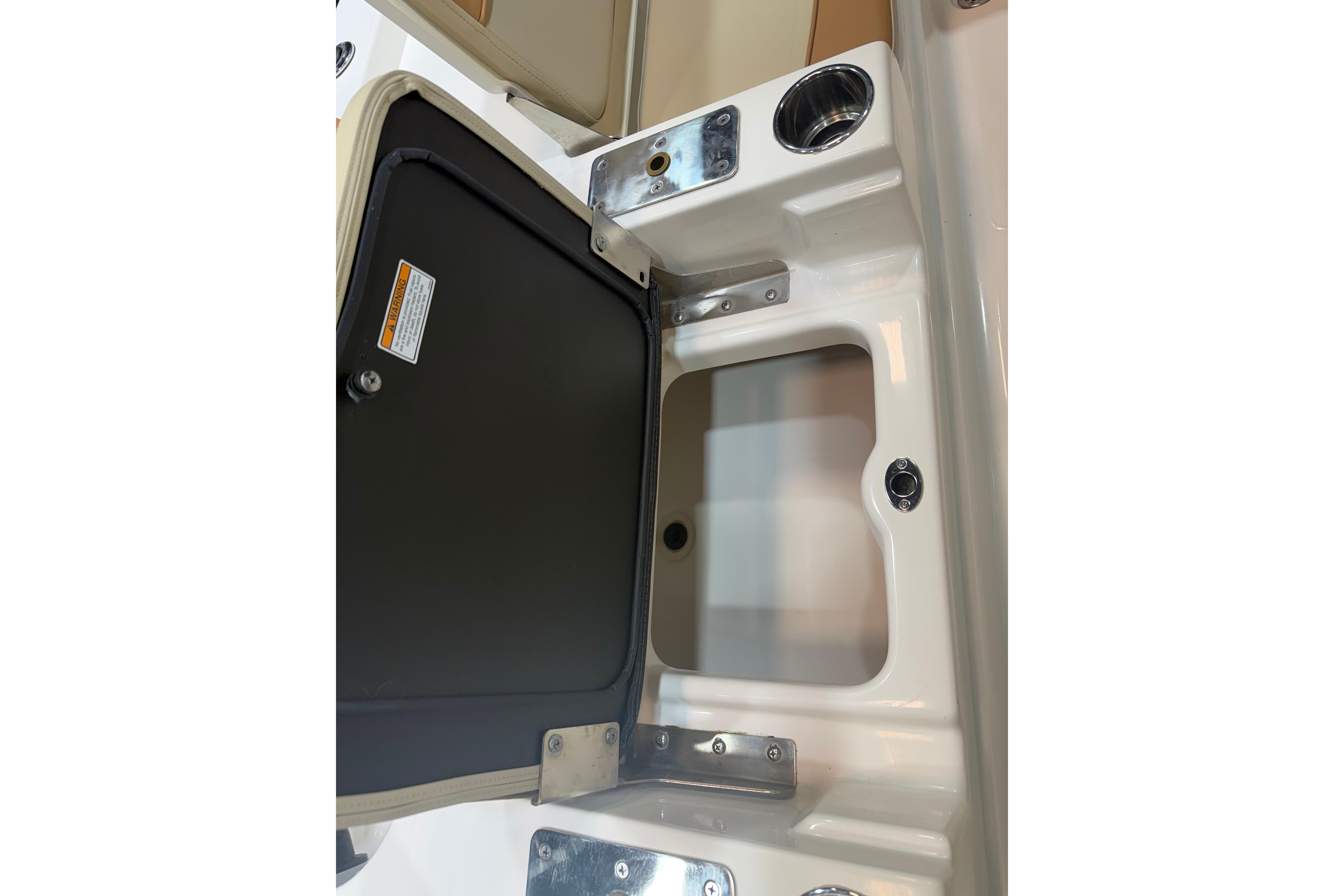 2023 NauticStar 215 XTS boat storage compartment with open hatch and cup holder.