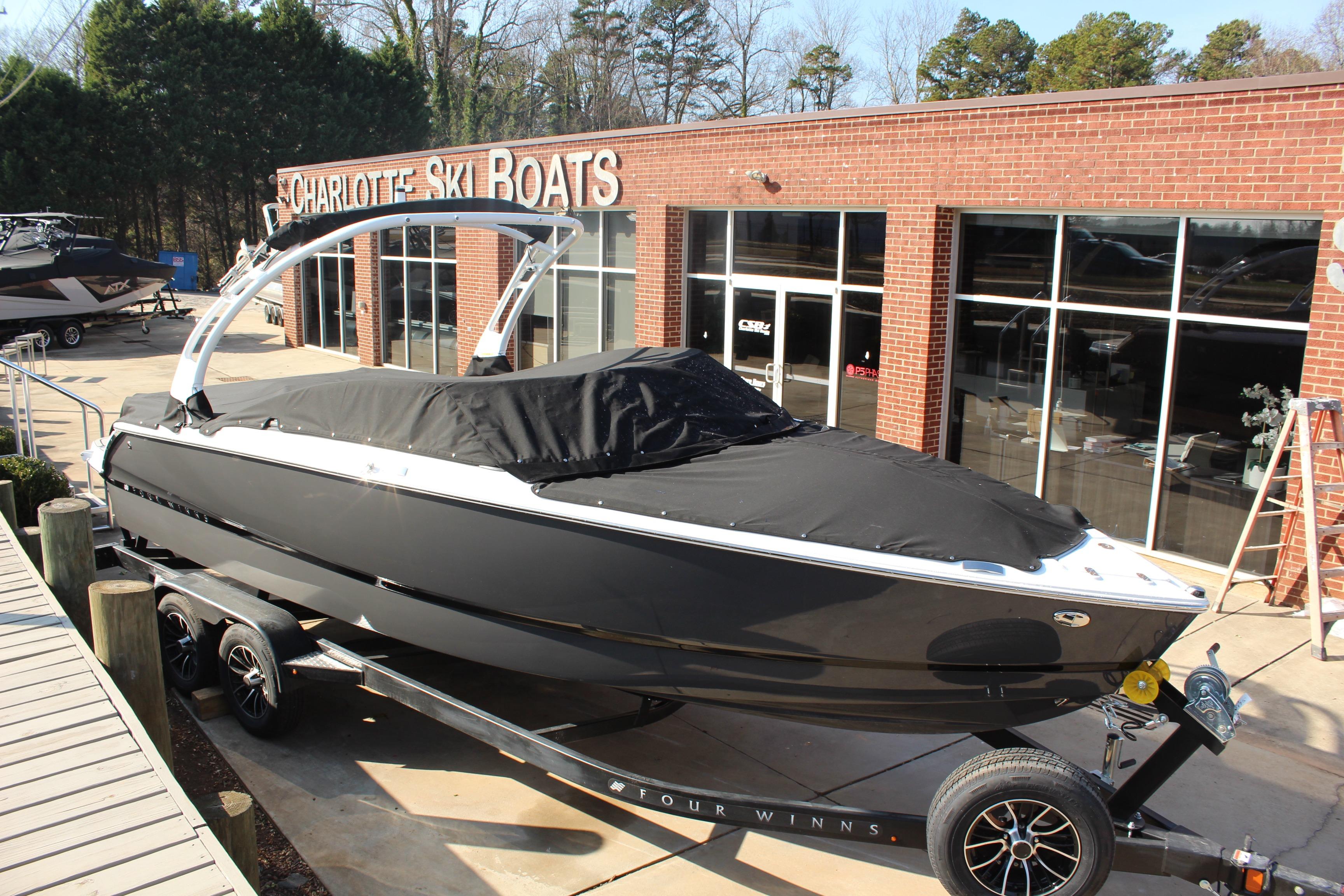 2026 Four Winns H4 boat covered, parked at Charlotte Ski Boats dealership.