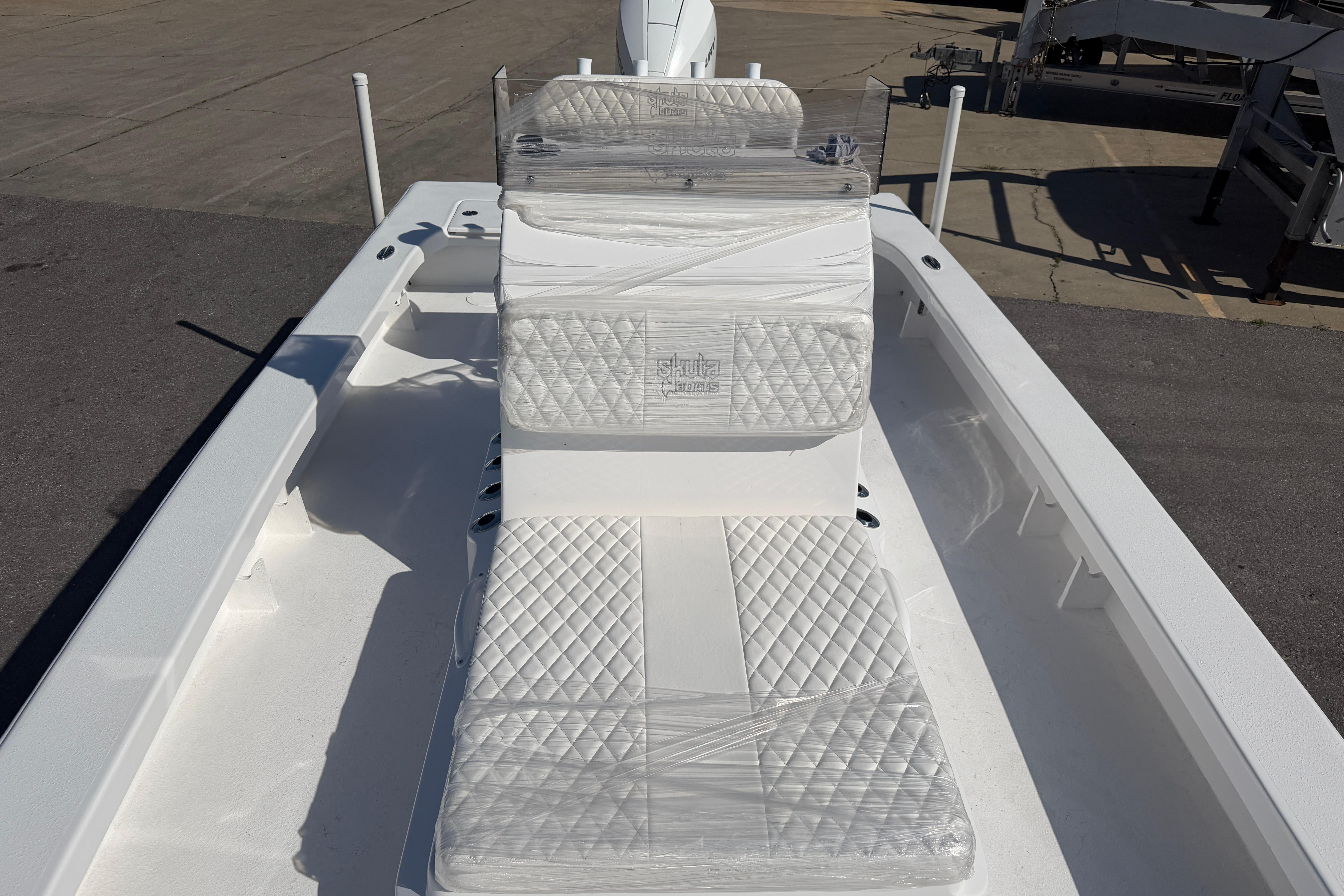 2026 Skuta 24 Cat boat with quilted seating, docked on a sunny day.
