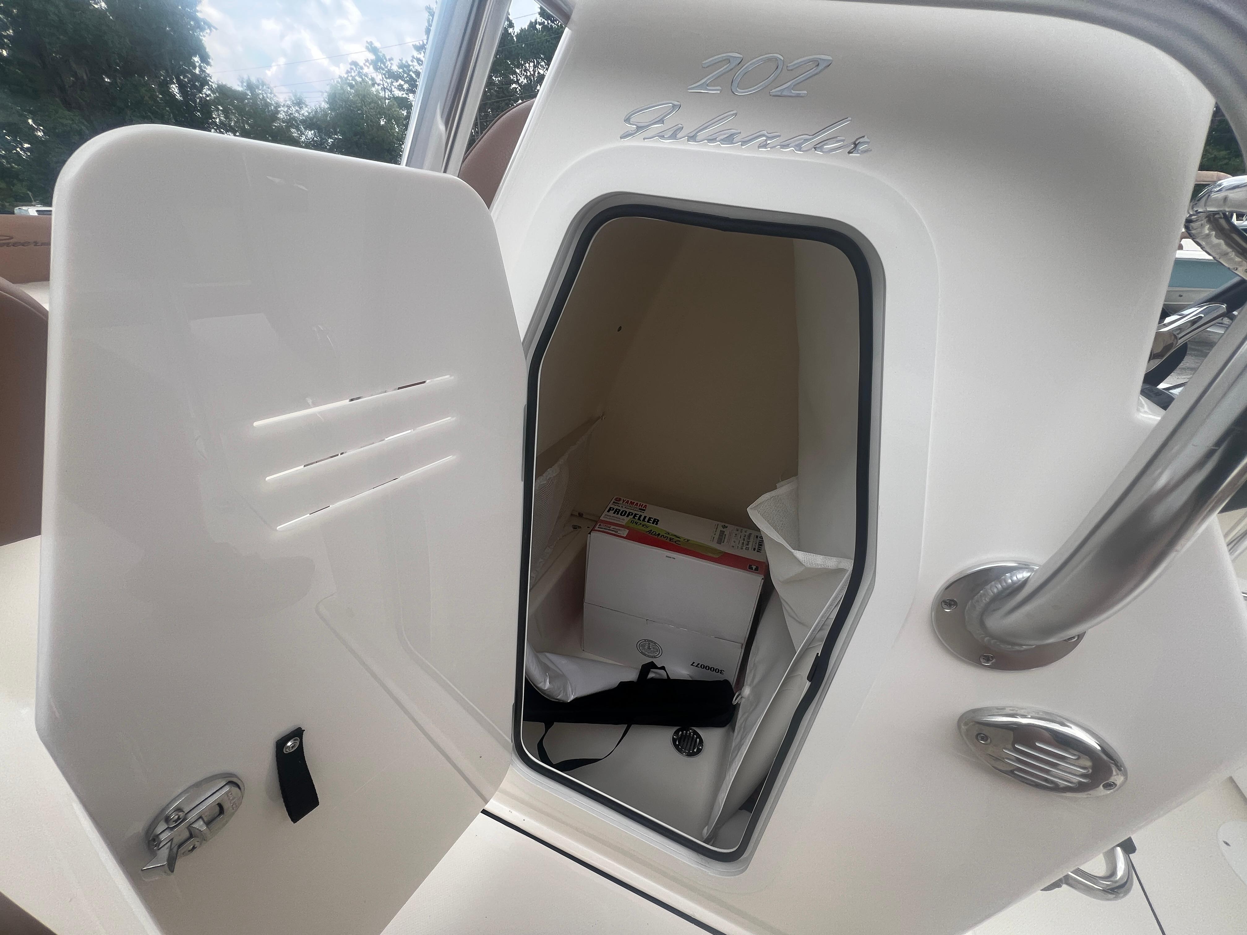 Open storage compartment on 2026 Pioneer 202 Islander boat, showing interior space and contents.