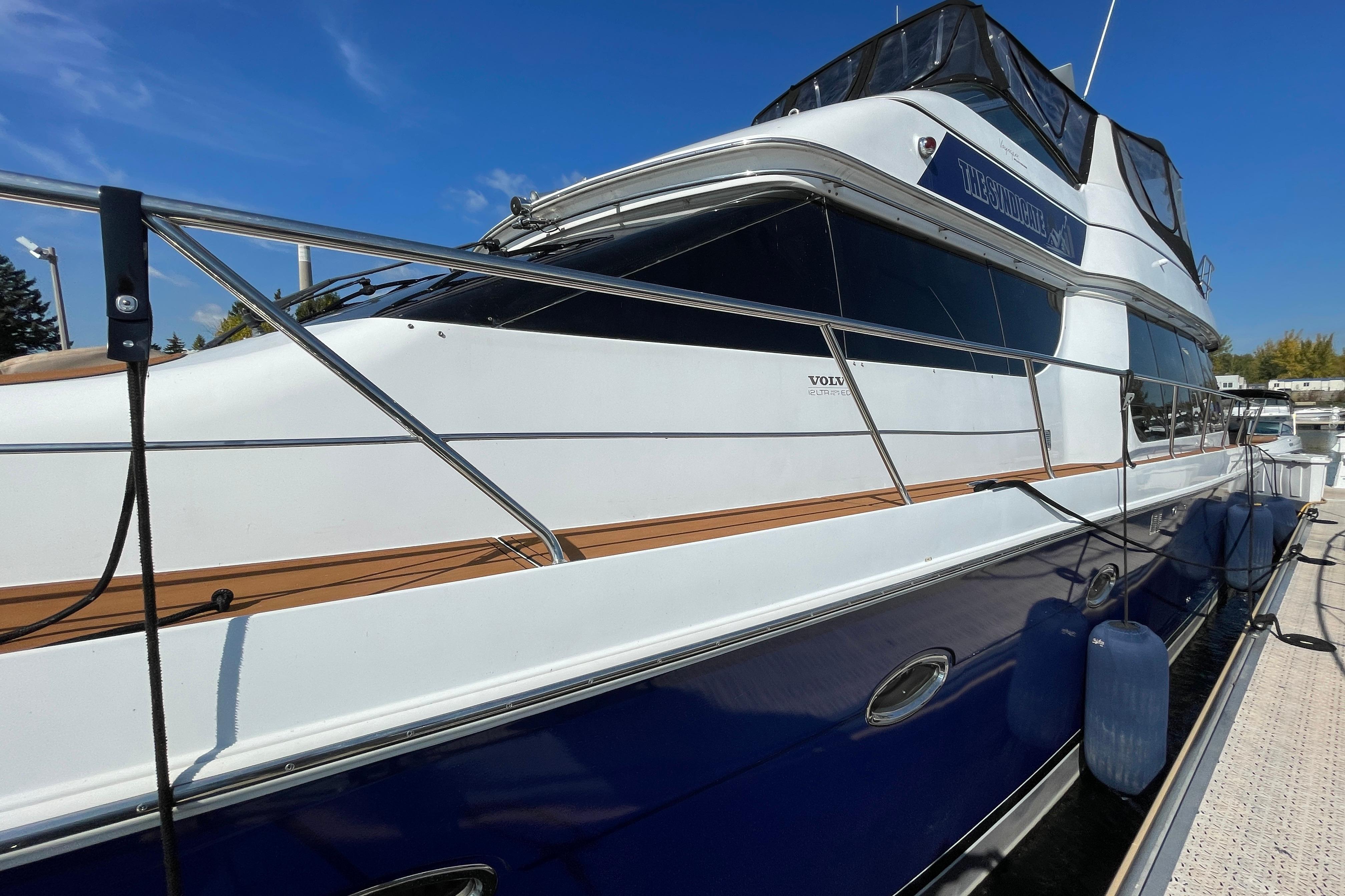 2002 Carver 570 Voyager Pilothouse yacht docked under clear blue sky.