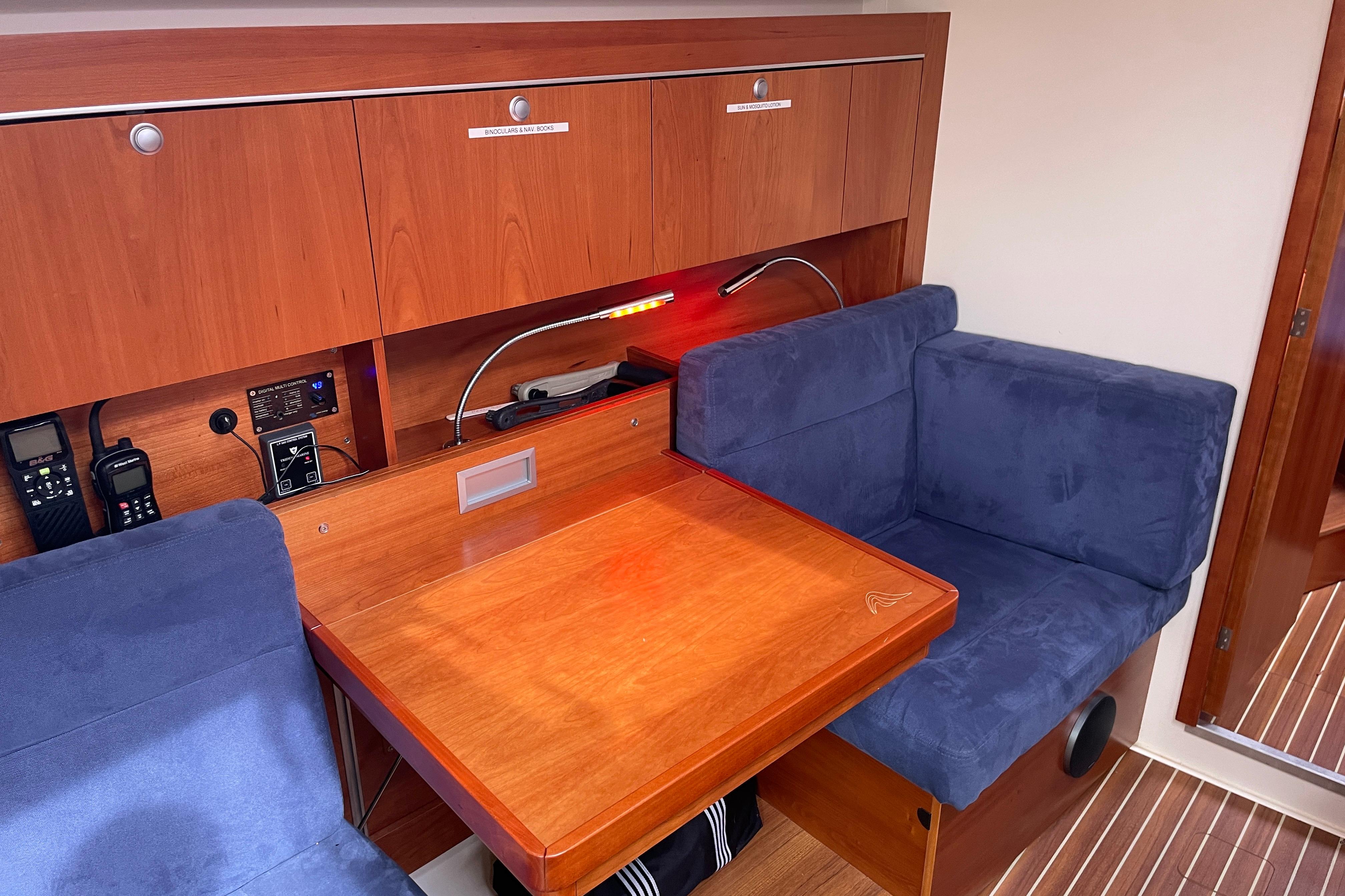 Interior of 2014 Hanse 415 yacht with wooden cabinetry and blue seating.