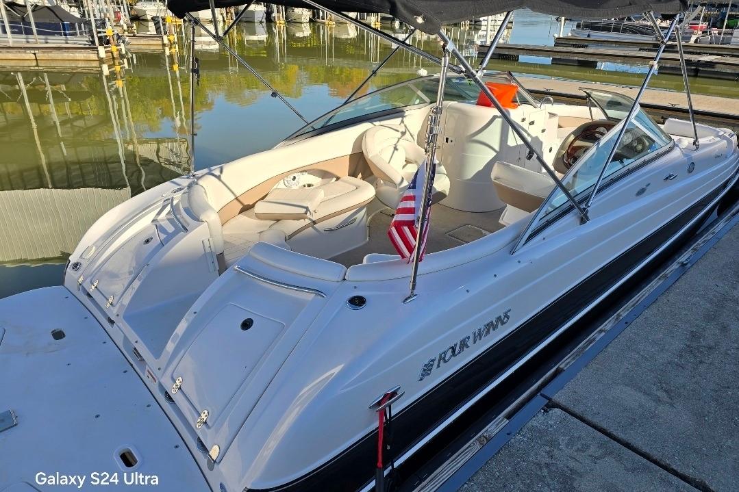2006 Four Winns 244 Funship boat docked, featuring spacious seating and sleek design.
