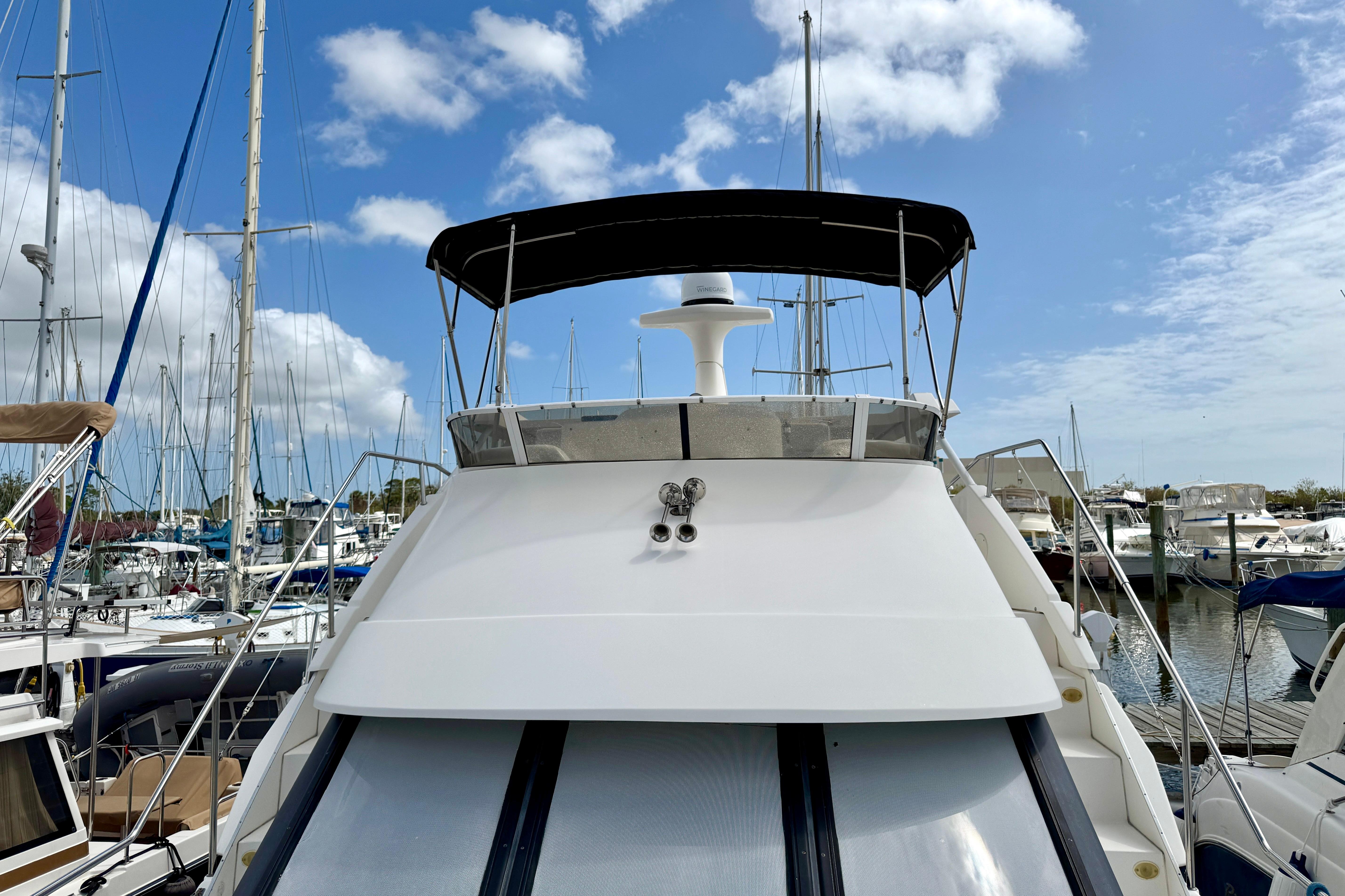 2000 Silverton 322 Motor Yacht docked at marina under blue sky.