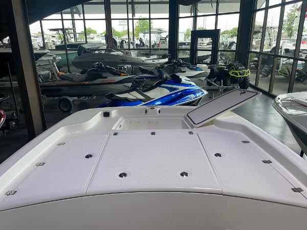 2024 Mako Pro Skiff 19 CC boat interior at a showroom with jet skis in the background.