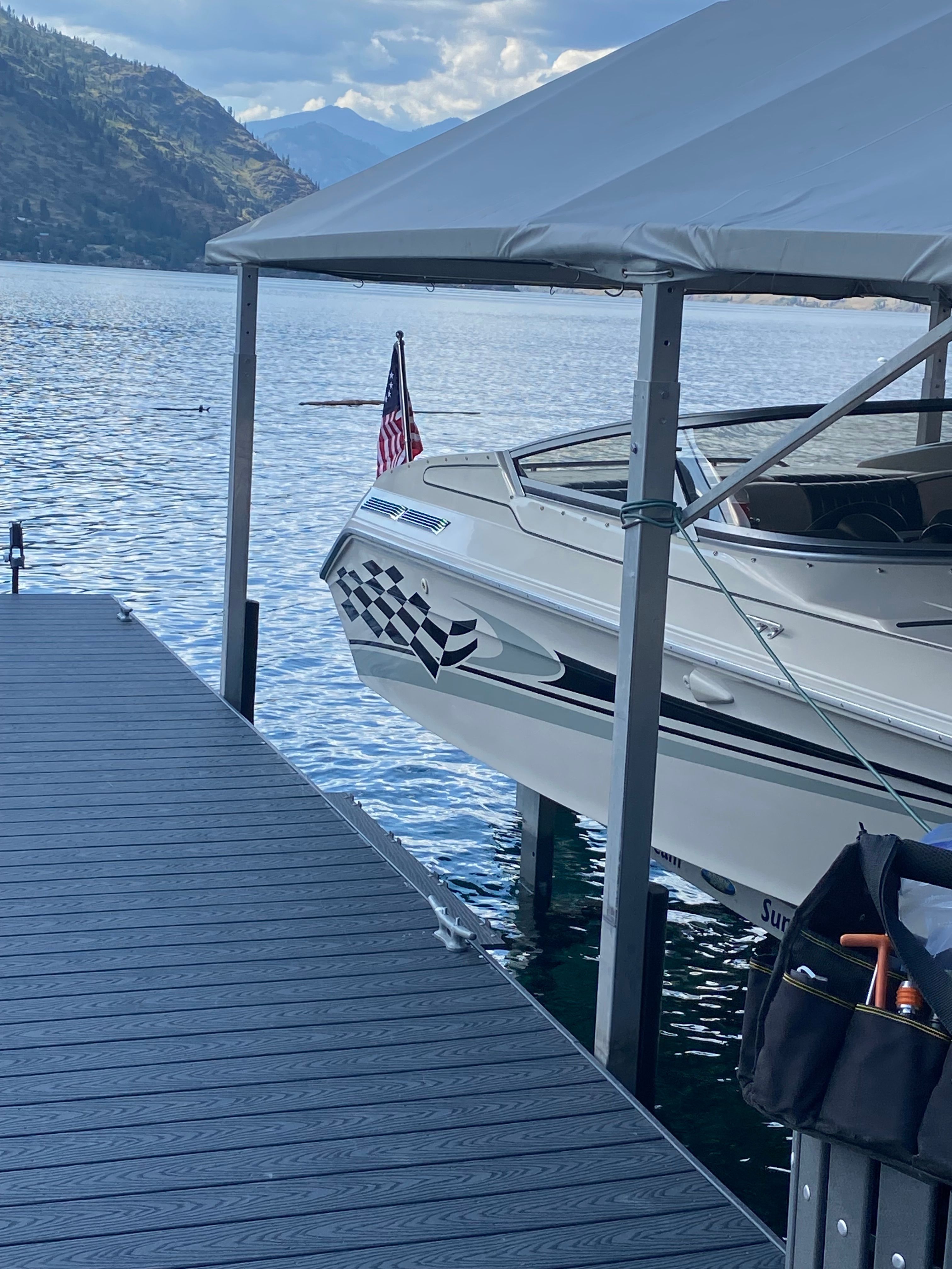 A 1986 Sea Ray Pachanga 11 docked by a lake with mountain views.