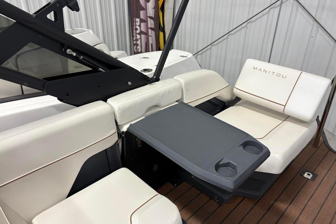 2023 Manitou EXPLORE 26 SHP 575 boat interior with seating and table.
