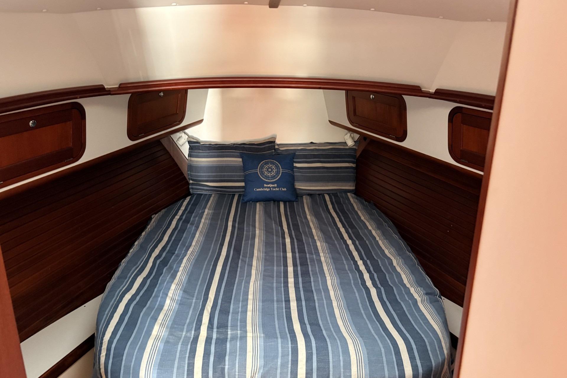Cozy boat cabin with striped bedding and wooden accents.