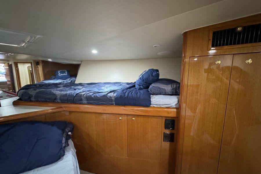 Cozy cabin interior of 2002 Viking 61 Enclosed Bridge yacht with wooden finishes.