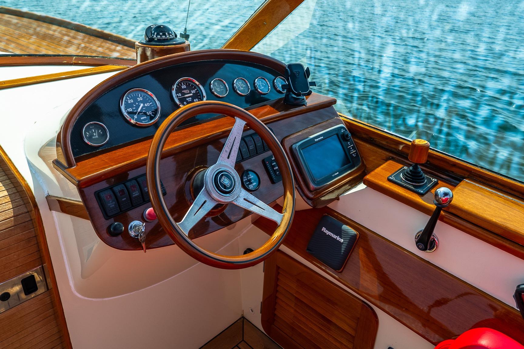 Helm of 2005 Hinckley Talaria 29R boat with wooden dashboard and steering wheel.