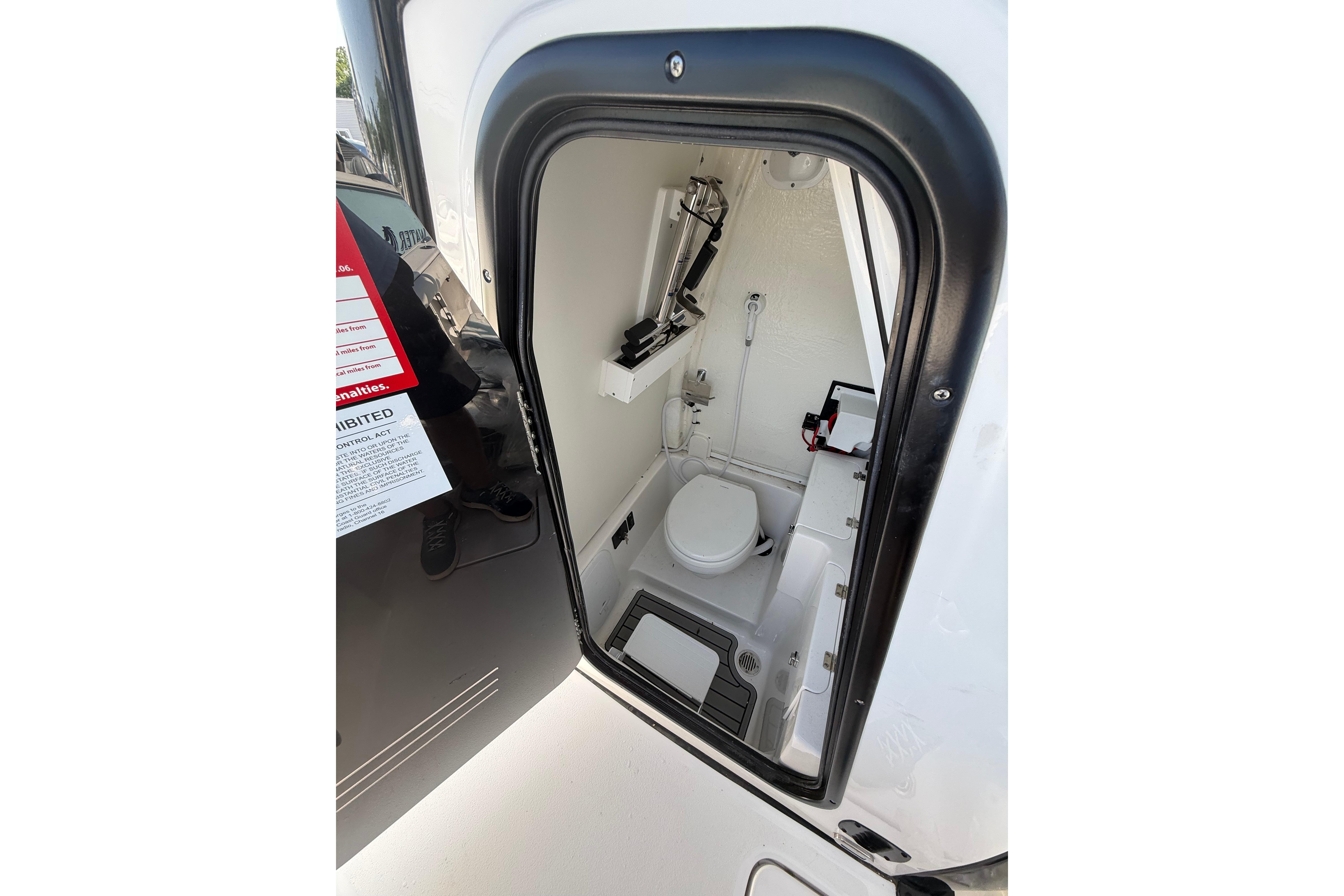 2026 Tidewater 256 CC Adventure boat interior with compact marine toilet.
