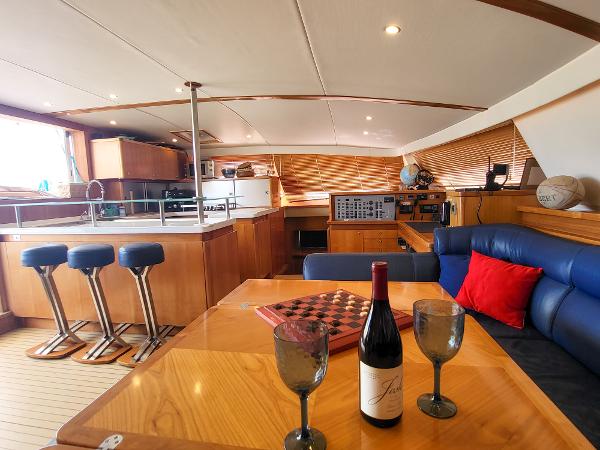 Luxurious interior of 2009 Catana 65 yacht with kitchen, seating, and wine setup.