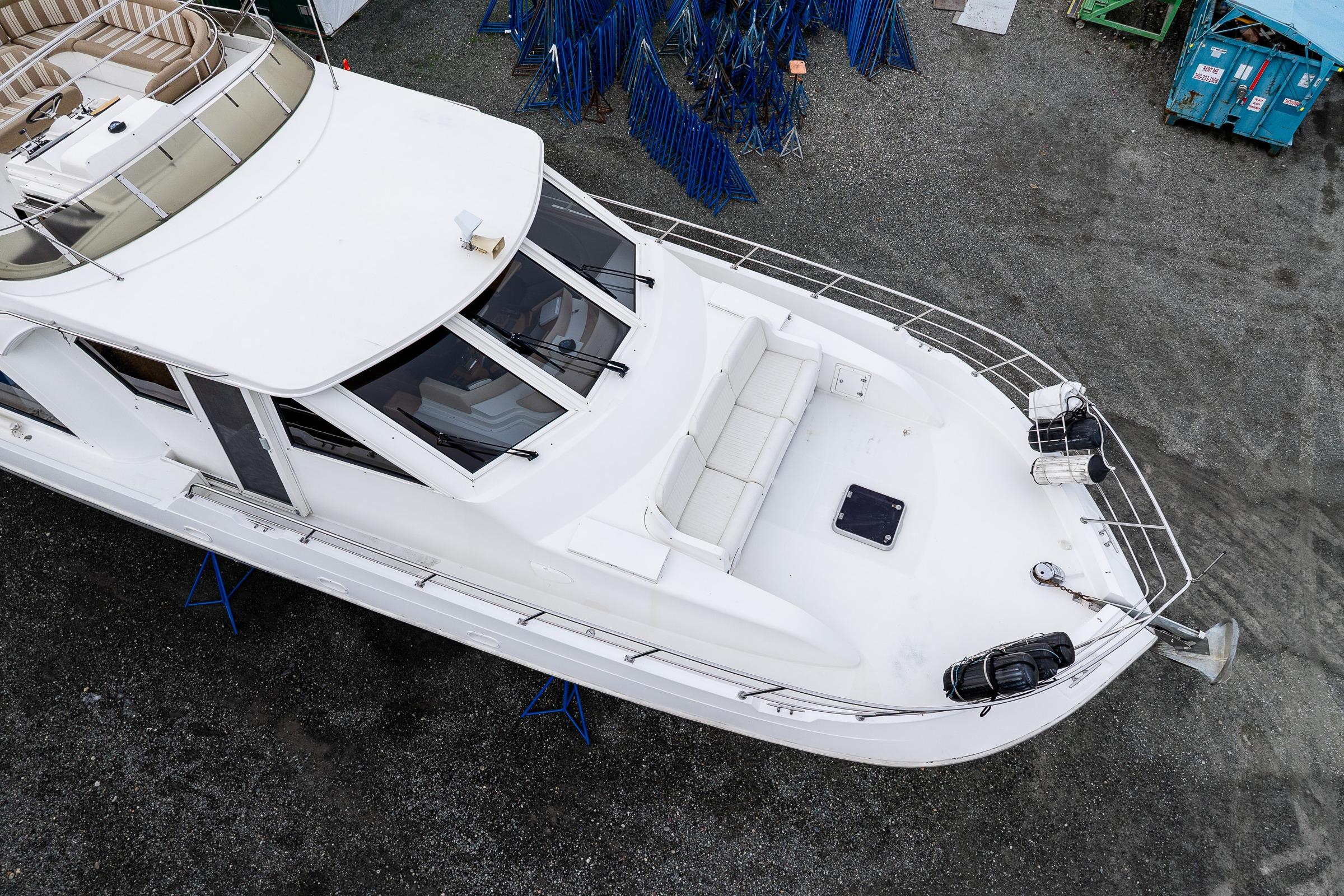 Aerial view of 2001 Navigator Pilothouse yacht on dry dock, showcasing spacious deck and seating.