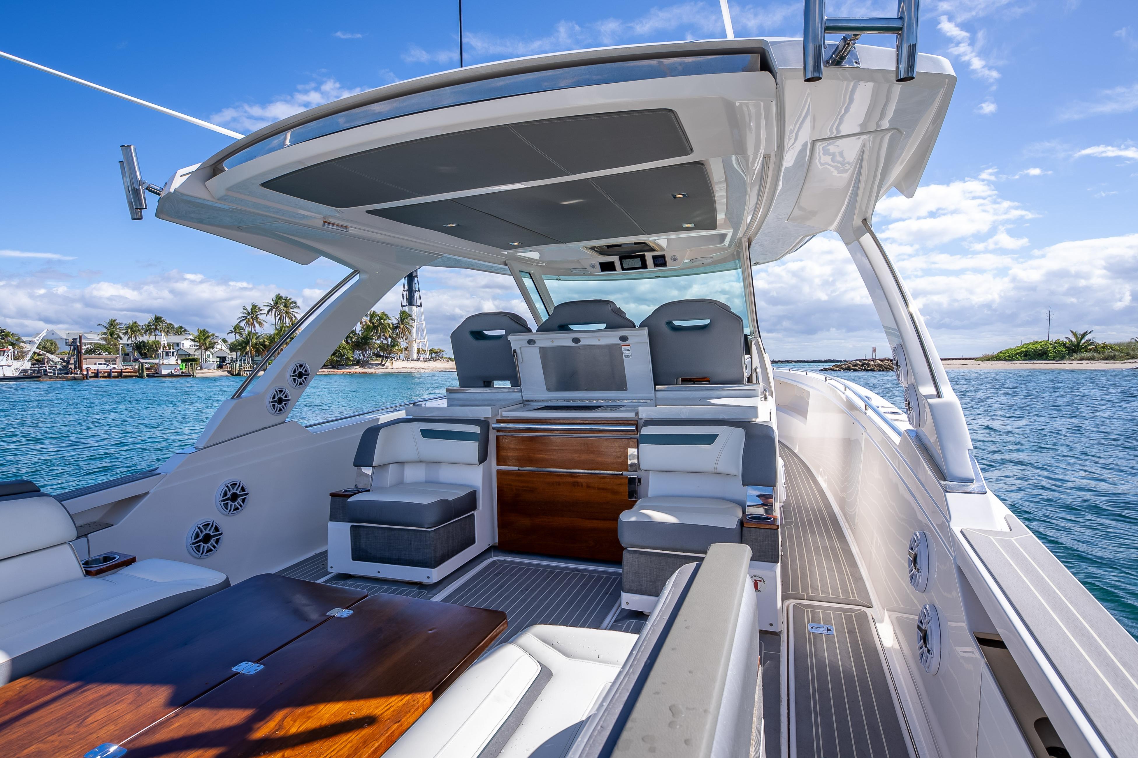 Luxurious 2019 Tiara Sport 38 LS yacht interior with seating, cruising on clear blue waters.