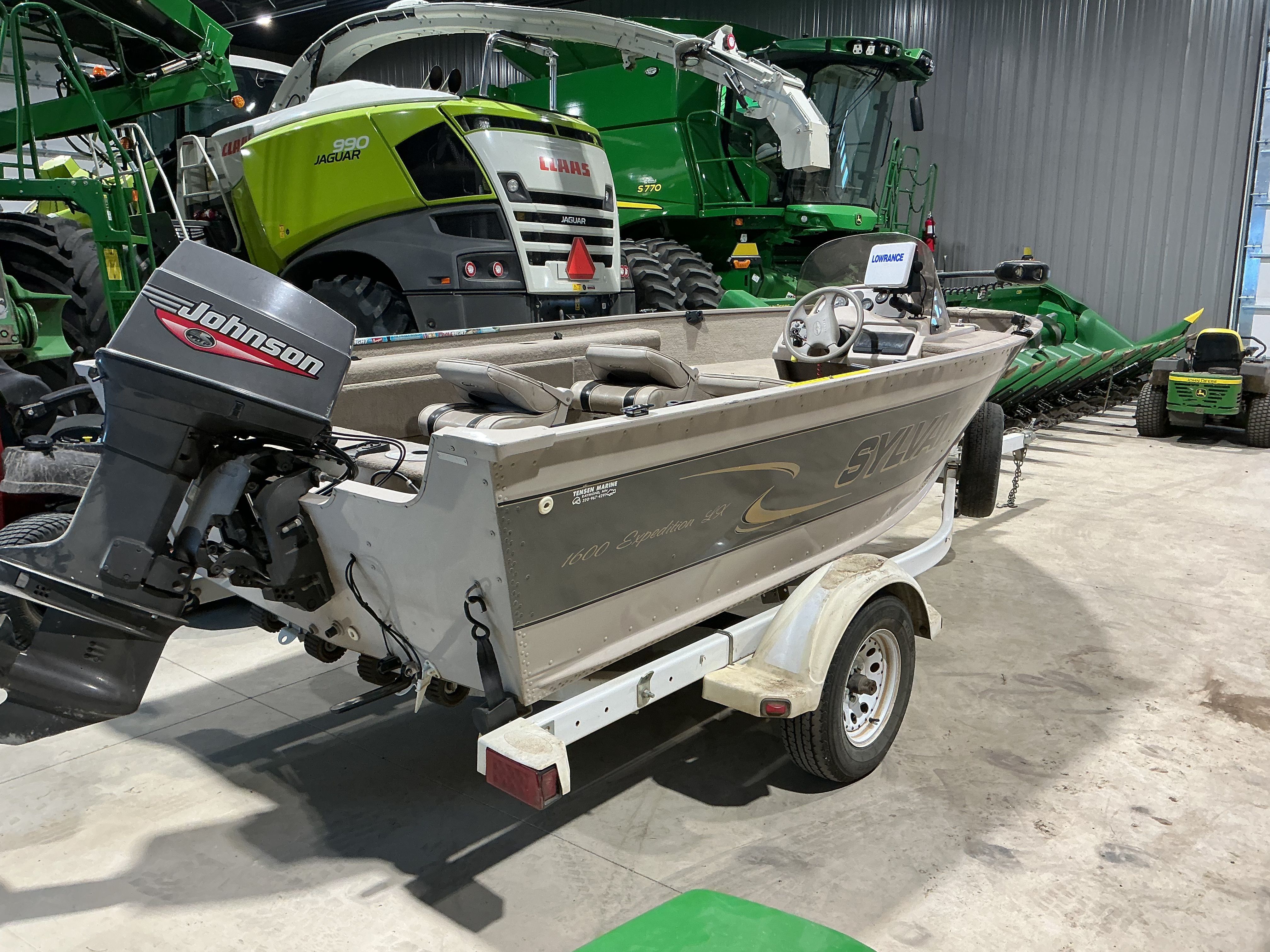 1999 Sylvan EXPEDITION boat with Johnson outboard motor in warehouse.