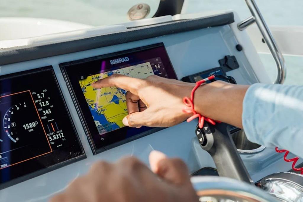 Person navigating with touchscreen on 2026 Bayliner Trophy T20CC boat.