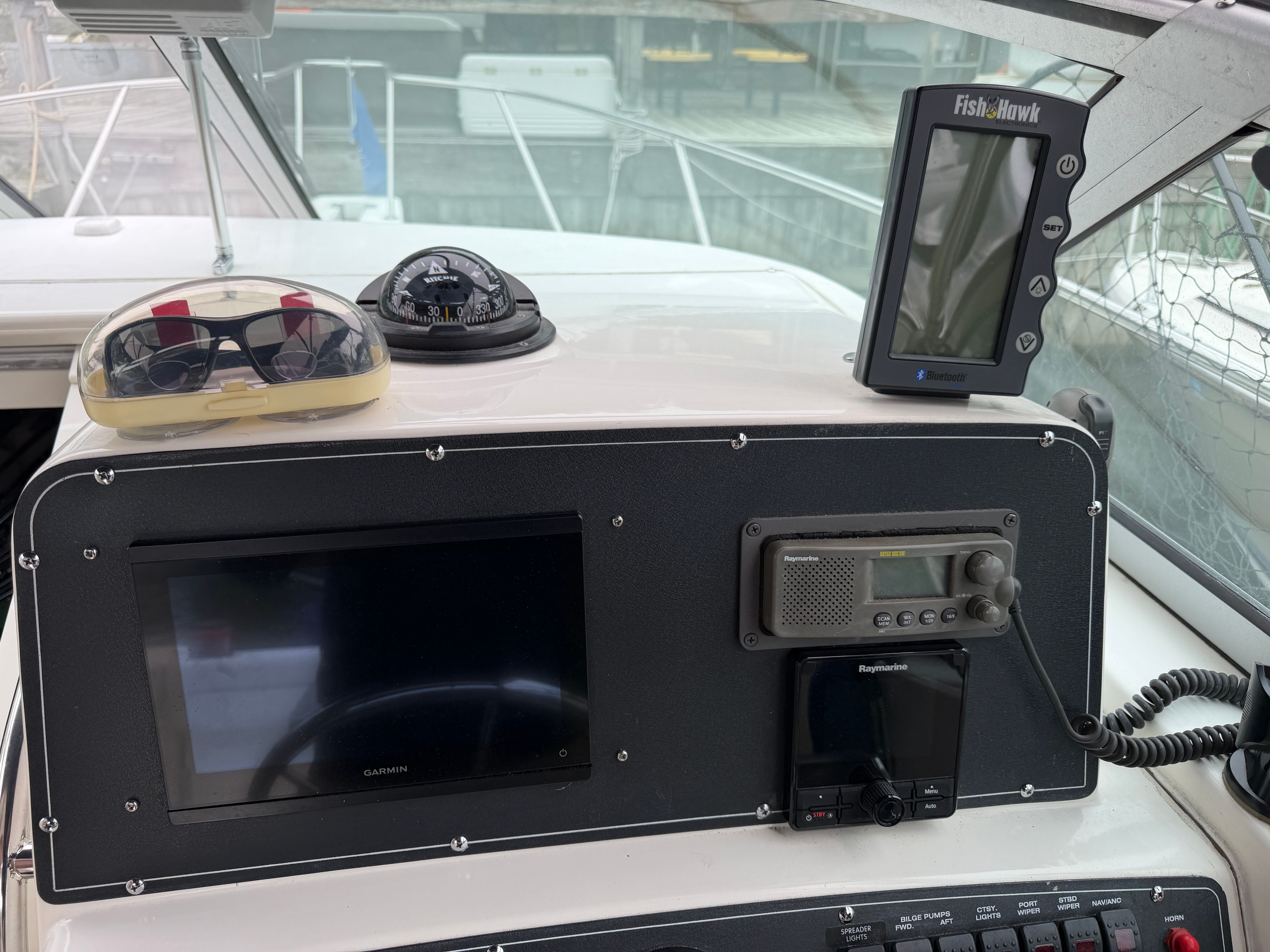The dashboard of a 2001 Boston Whaler 26 Conquest with navigation equipment and a radio.