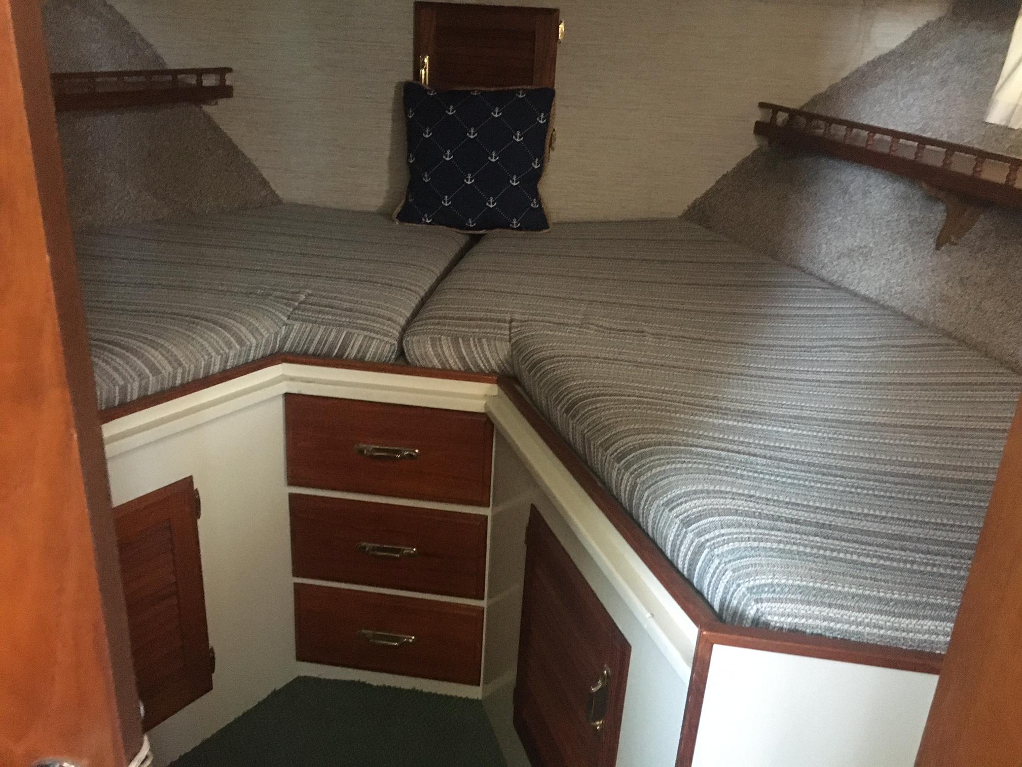 1978 Tollycraft 40 Tri-Cabin MY interior with twin beds and wooden storage drawers.