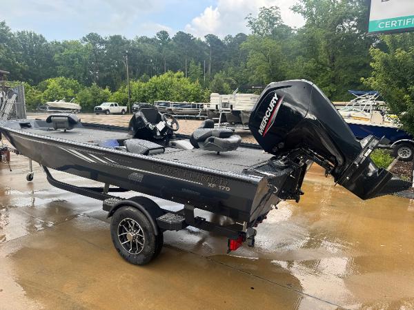 2025 Crestliner XF 179 boat with Mercury engine on a trailer, parked outdoors.