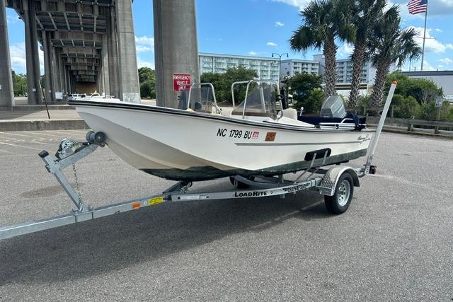 1989 Henry O 150 Dual Console boat on Load Rite trailer in parking lot.