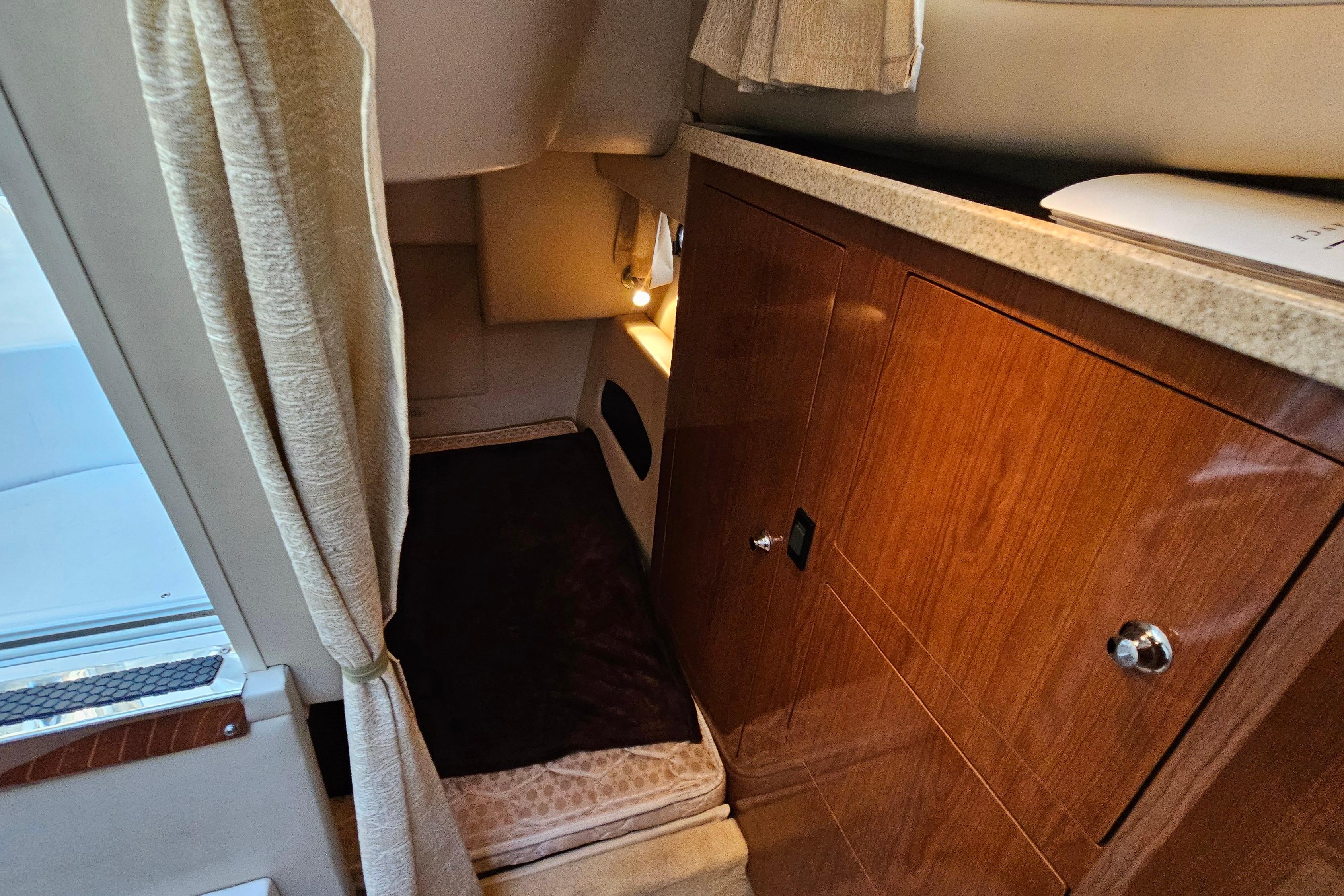 2005 Regal 3060 Window Express cabin interior with wood cabinetry and cozy sleeping area.