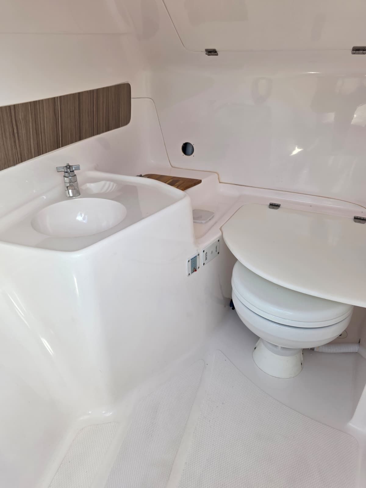 The image shows a modern boat bathroom with a sink and toilet.
