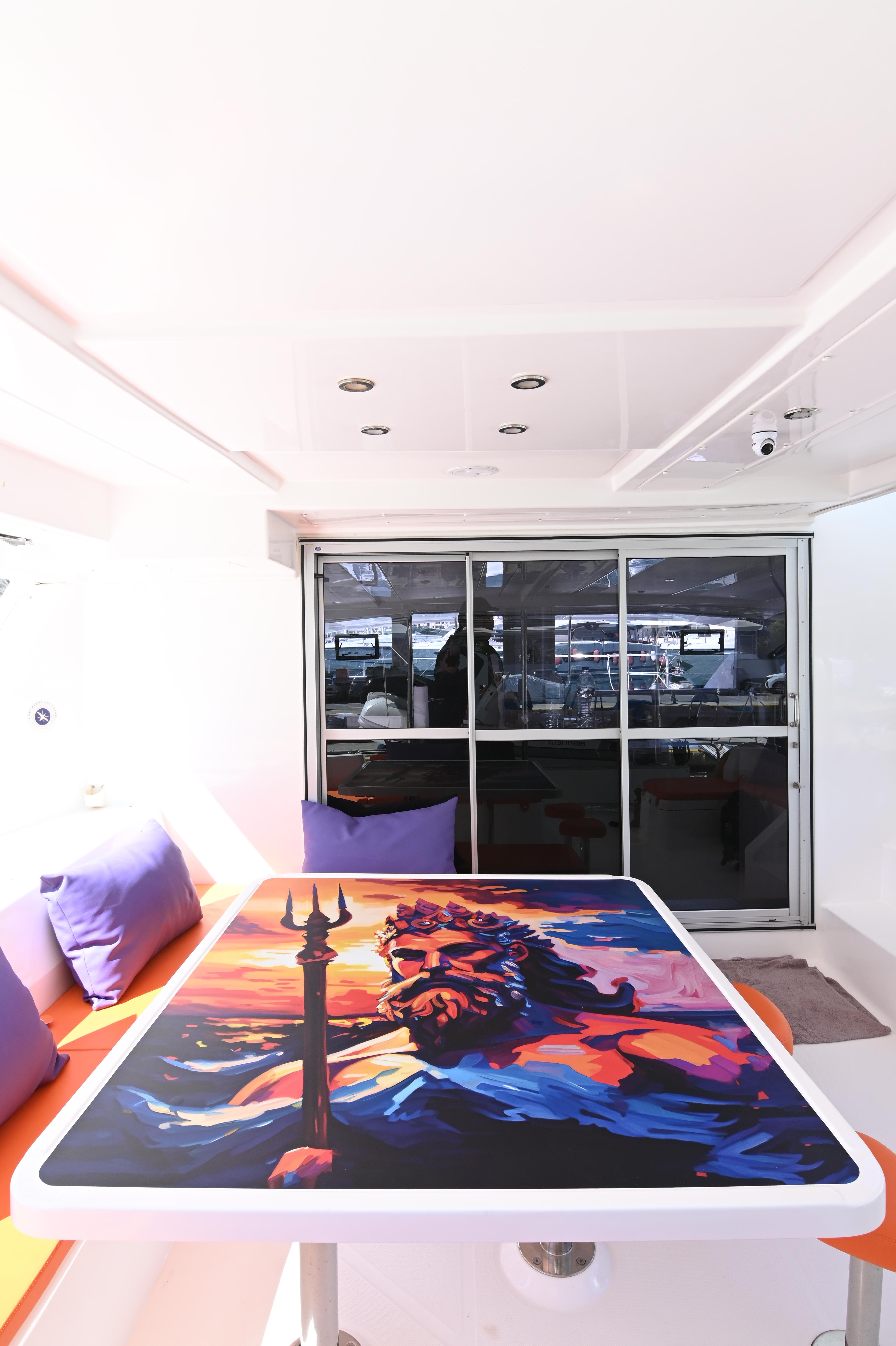 2017 Leopard 51 Powercat interior with vibrant artwork on table, purple cushions, and modern design.