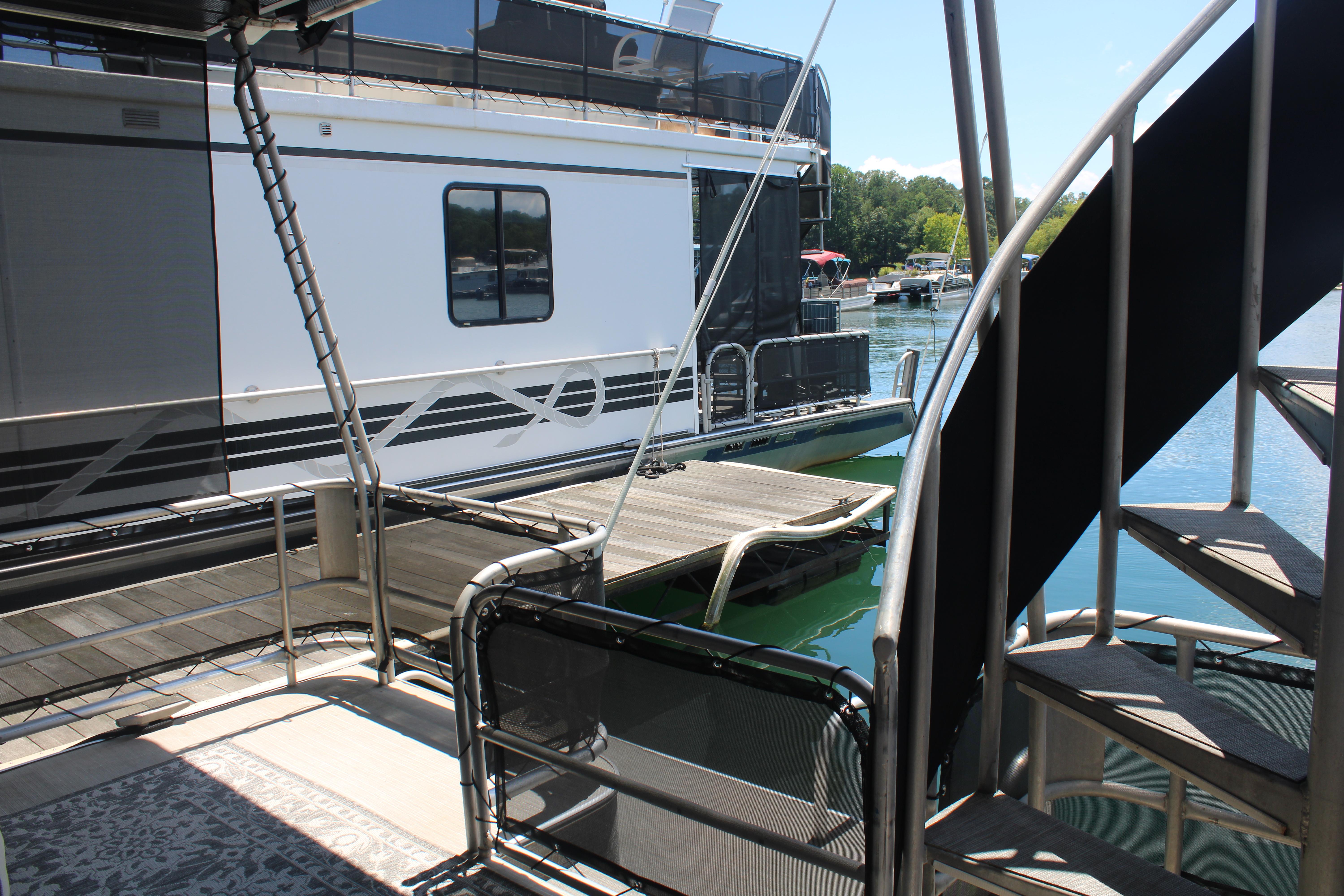 1992 Sumerset 66 houseboat docked, featuring outdoor deck and spiral staircase.
