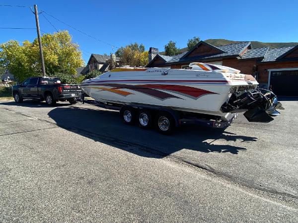 2002 Advantage Victory boat on trailer, parked on street, attached to a black truck.