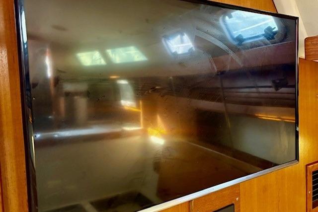 Flat-screen TV inside 1992 Catalina 34 yacht cabin, reflecting interior details.