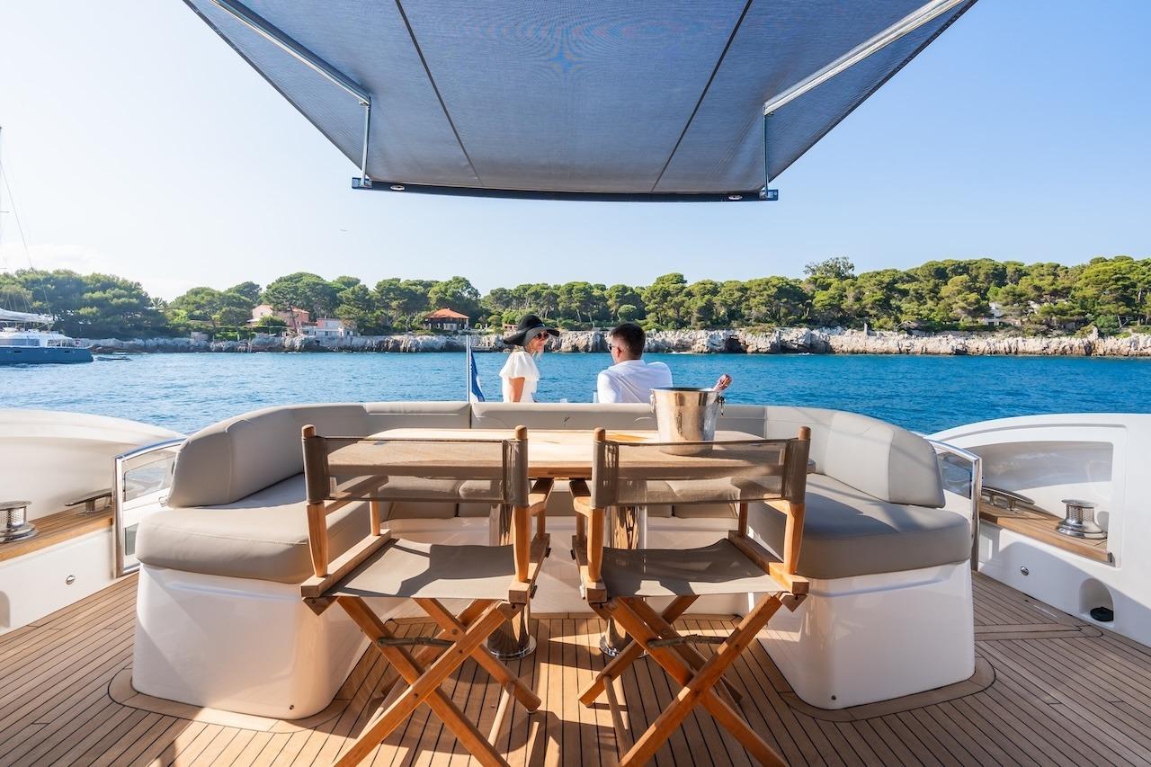 Luxury 2019 Princess V60 yacht deck with seating, ocean view, and sunshade.