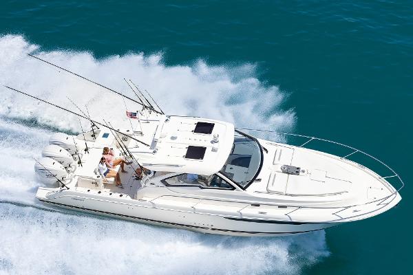 2025 Pursuit OS 405 boat cruising on clear blue water, showcasing sleek design and powerful engines.