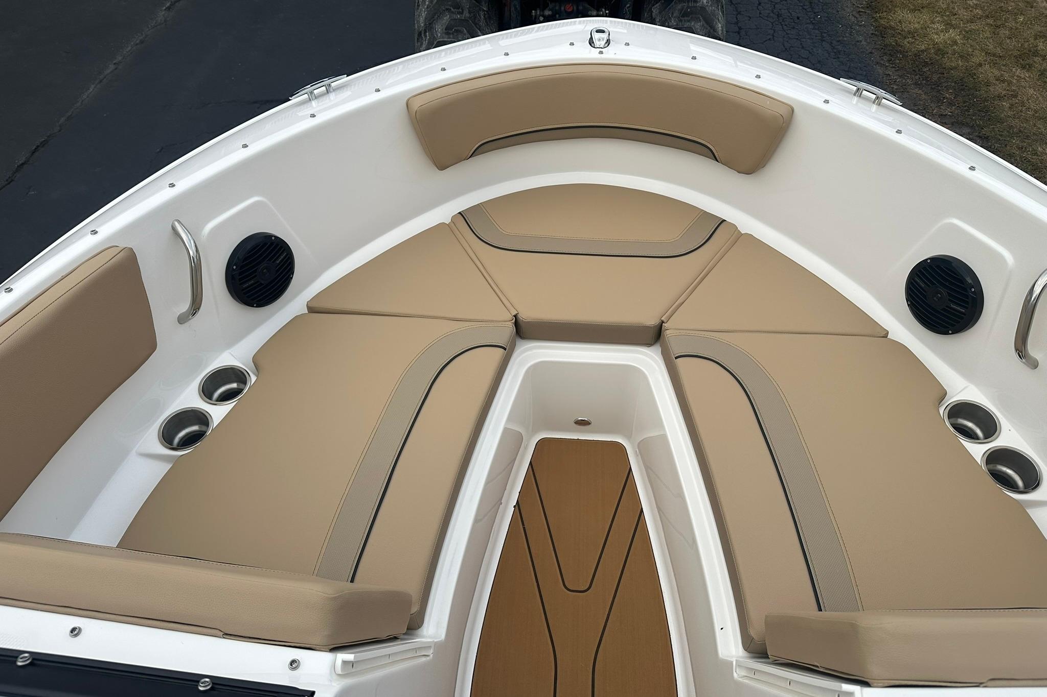 2026 Bayliner V20 boat interior with beige seating and cup holders.